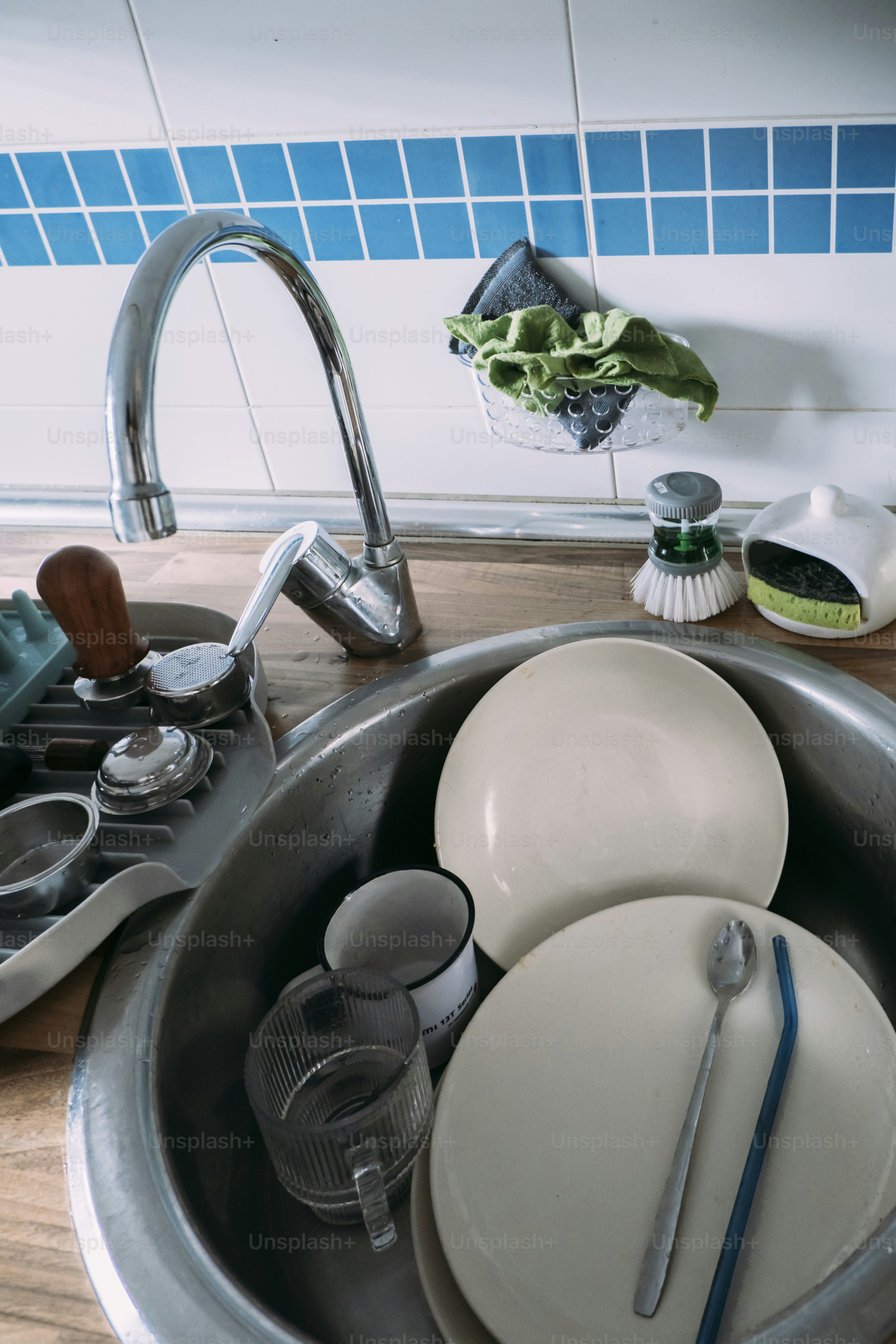 Dirty dishes are stacked in a sink.