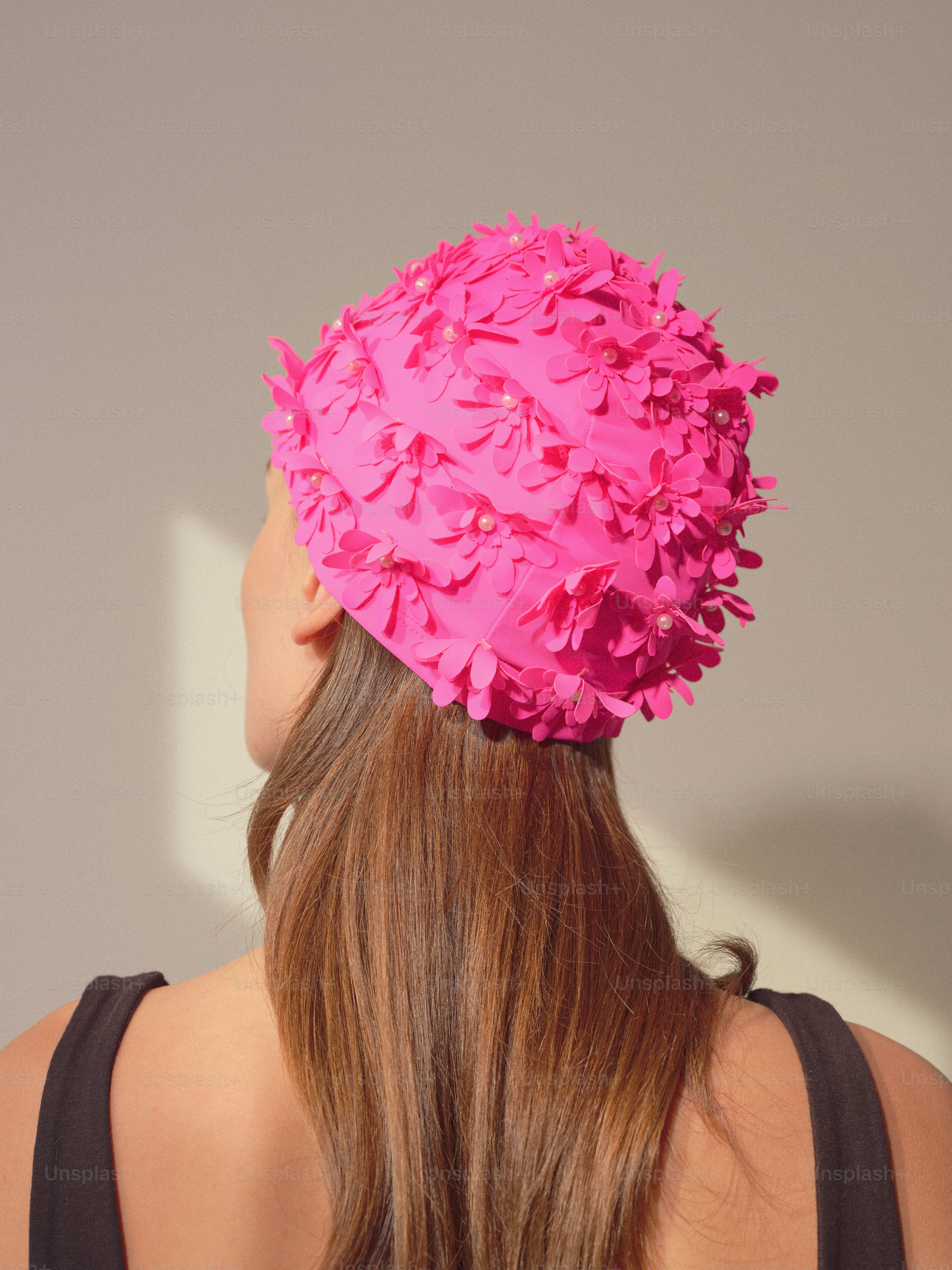 La donna indossa una cuffia da bagno floreale rosa vivace.