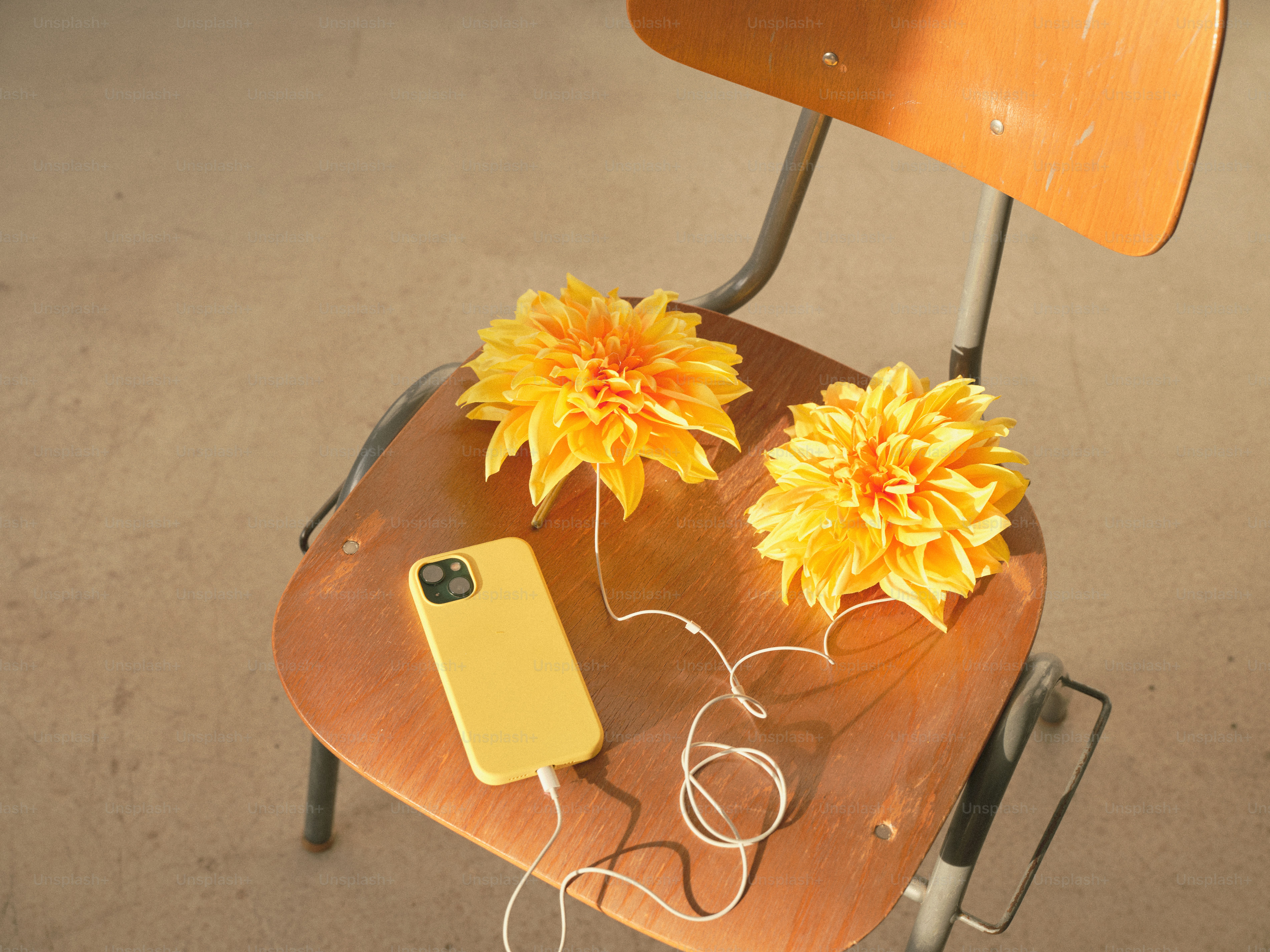 Yellow flowers and a phone rest on a chair.