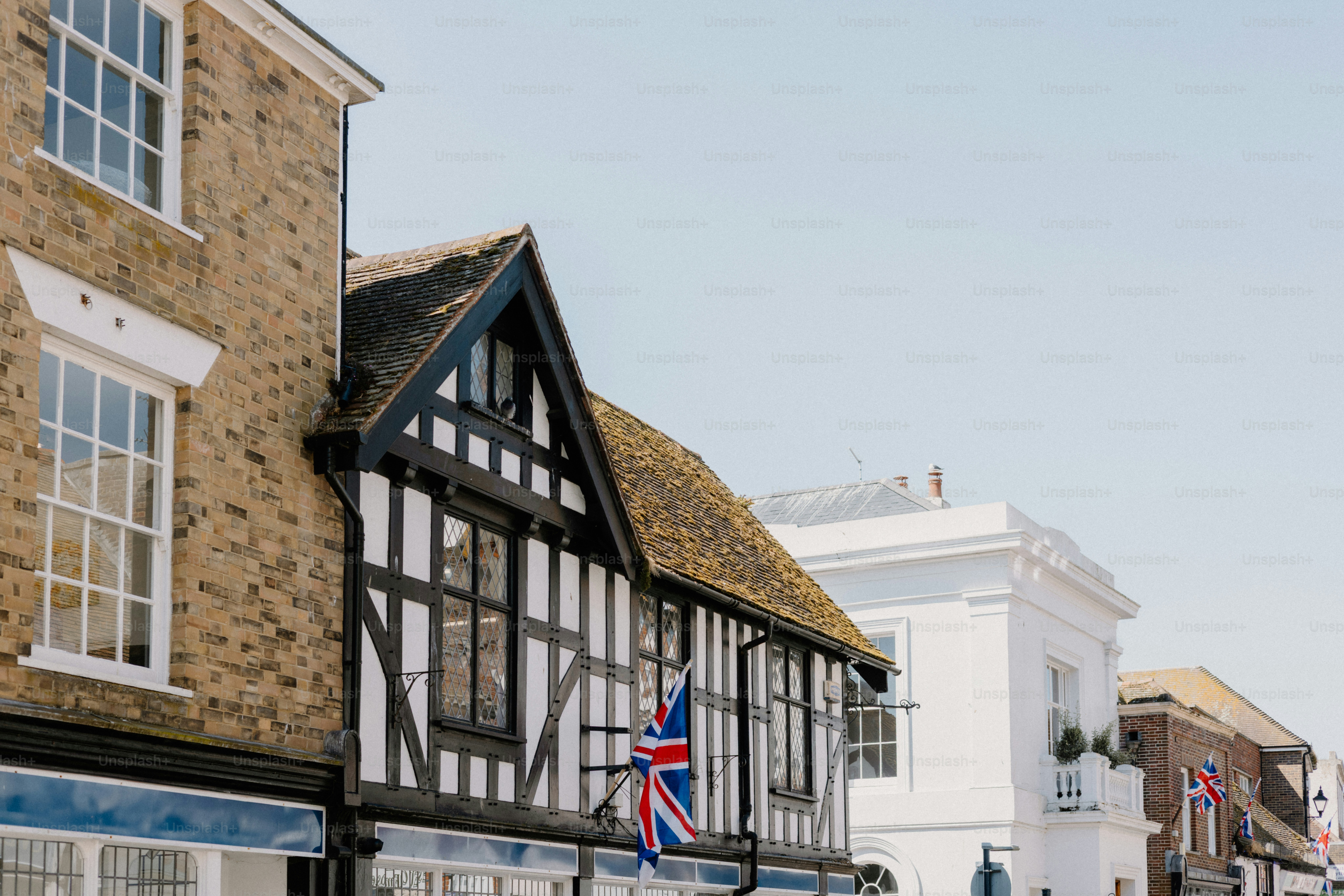 Edifícios pitorescos se alinham em uma rua ensolarada na Inglaterra.