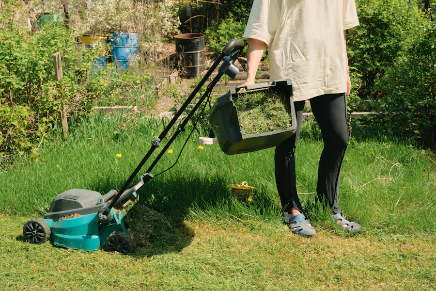 Close-up of hands on a gas mower handle over green grass