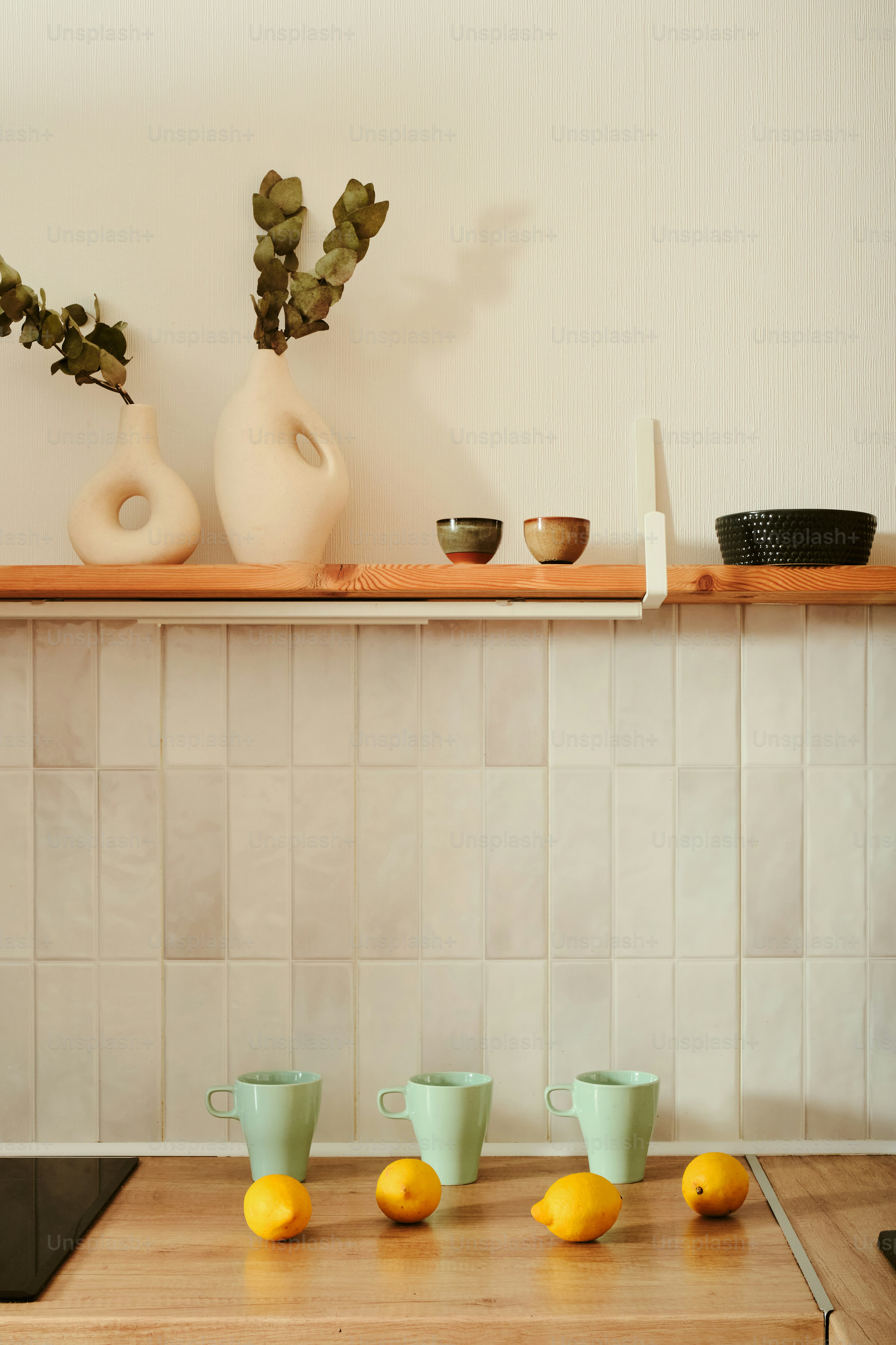Kitchen decor: vases, bowls, cups, and lemons on display.
