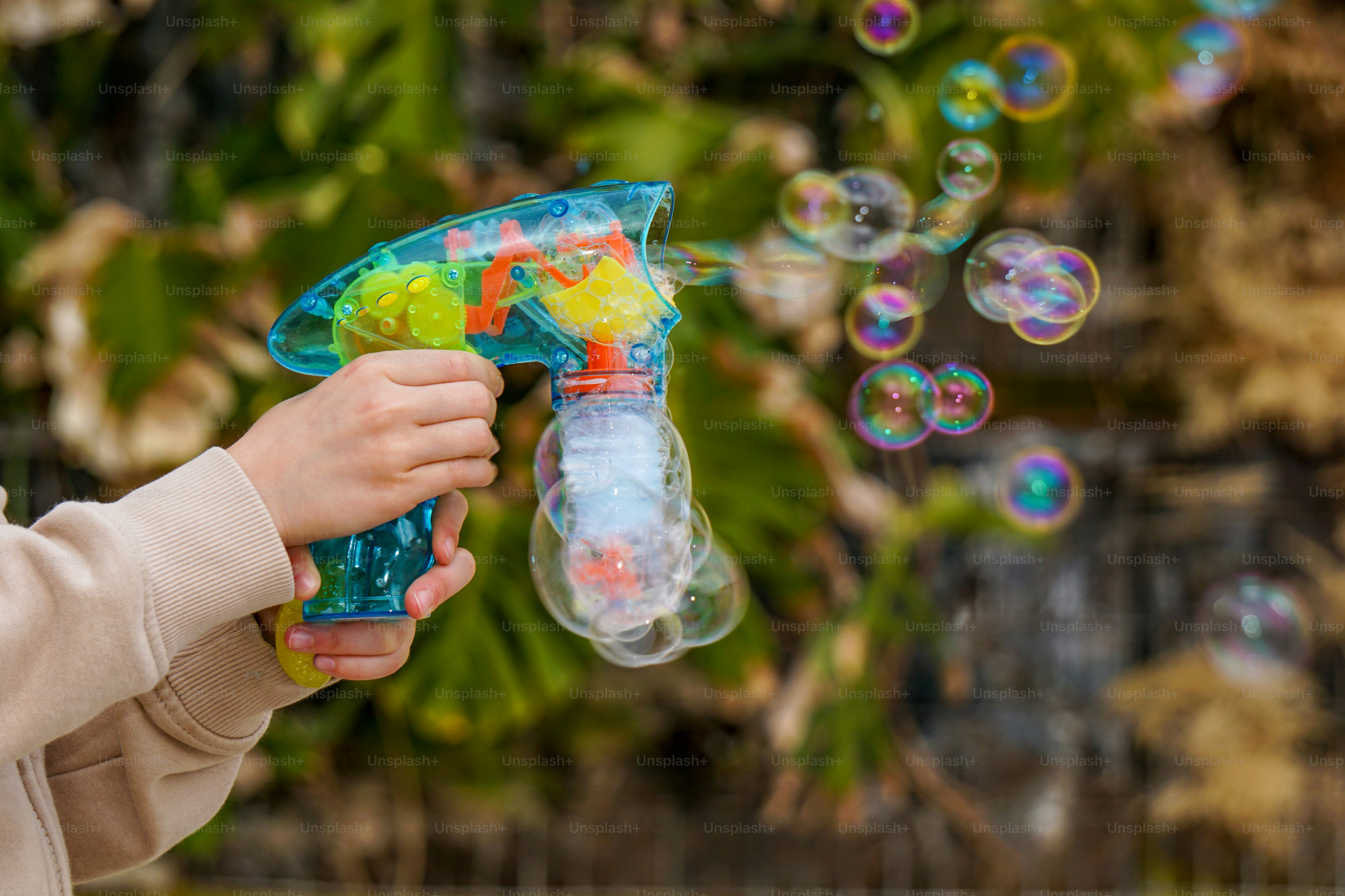 A child shoots bubbles from a toy gun.