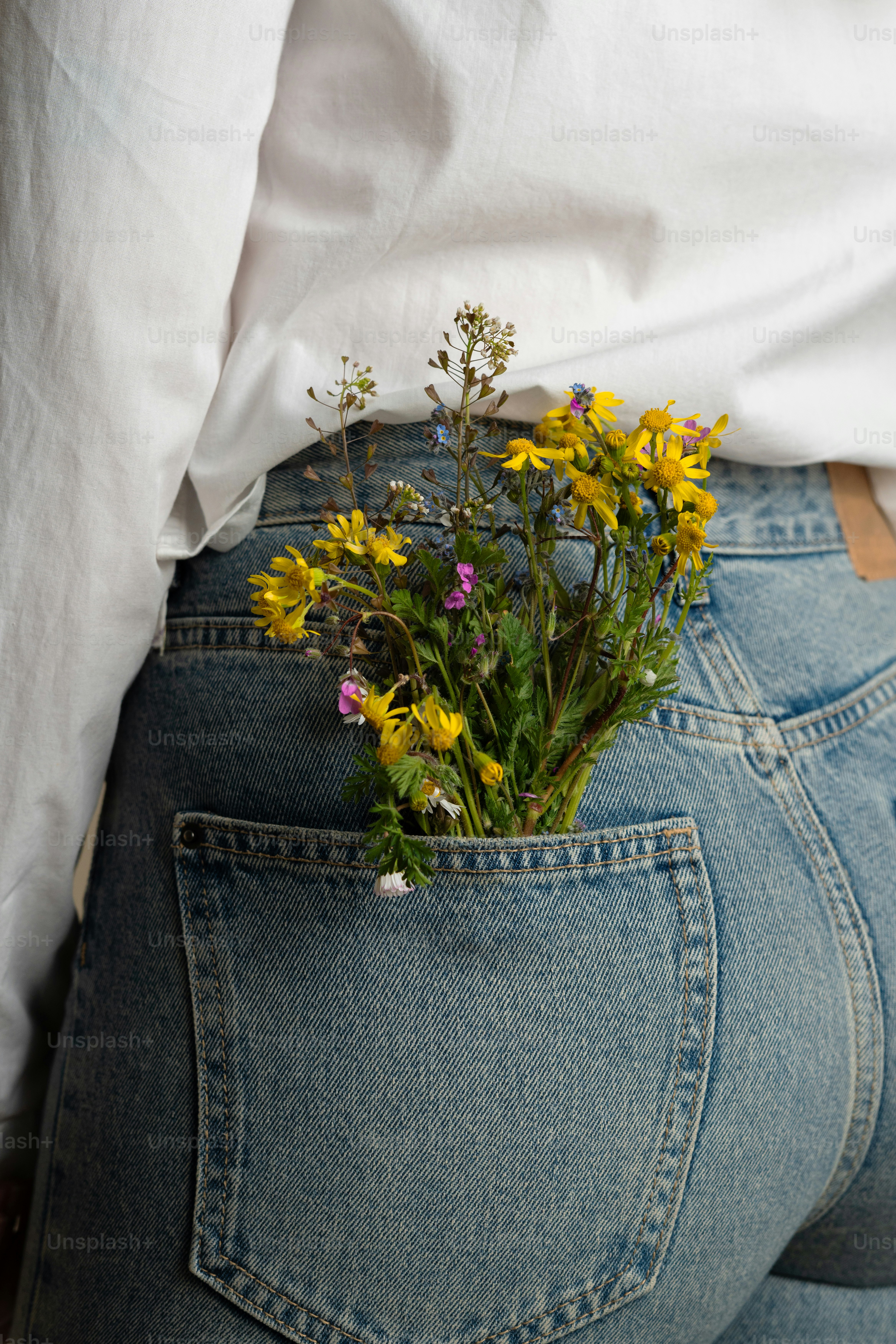 Las flores brotan del bolsillo trasero de los vaqueros.