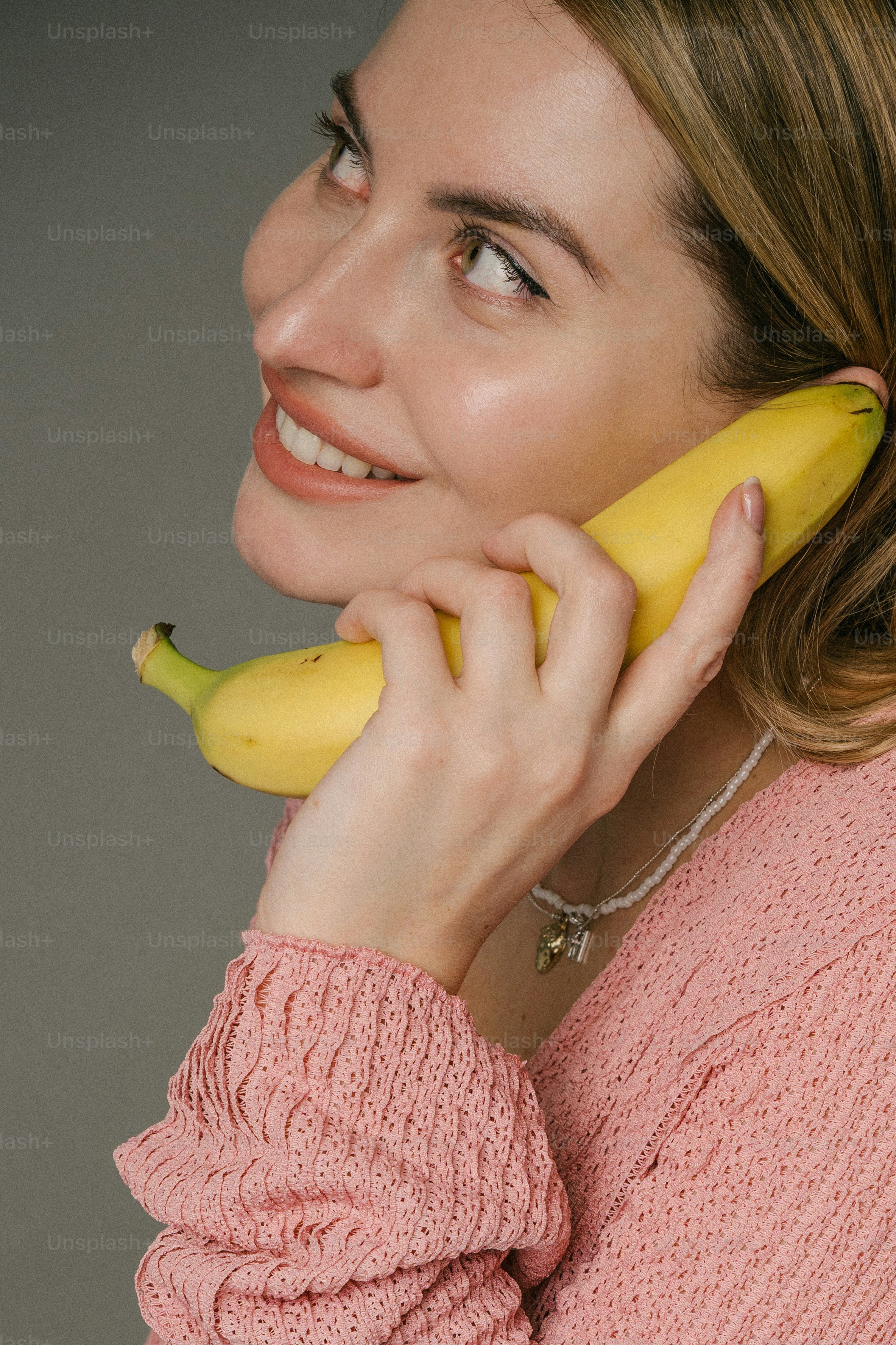 Woman pretends a banana is a phone.