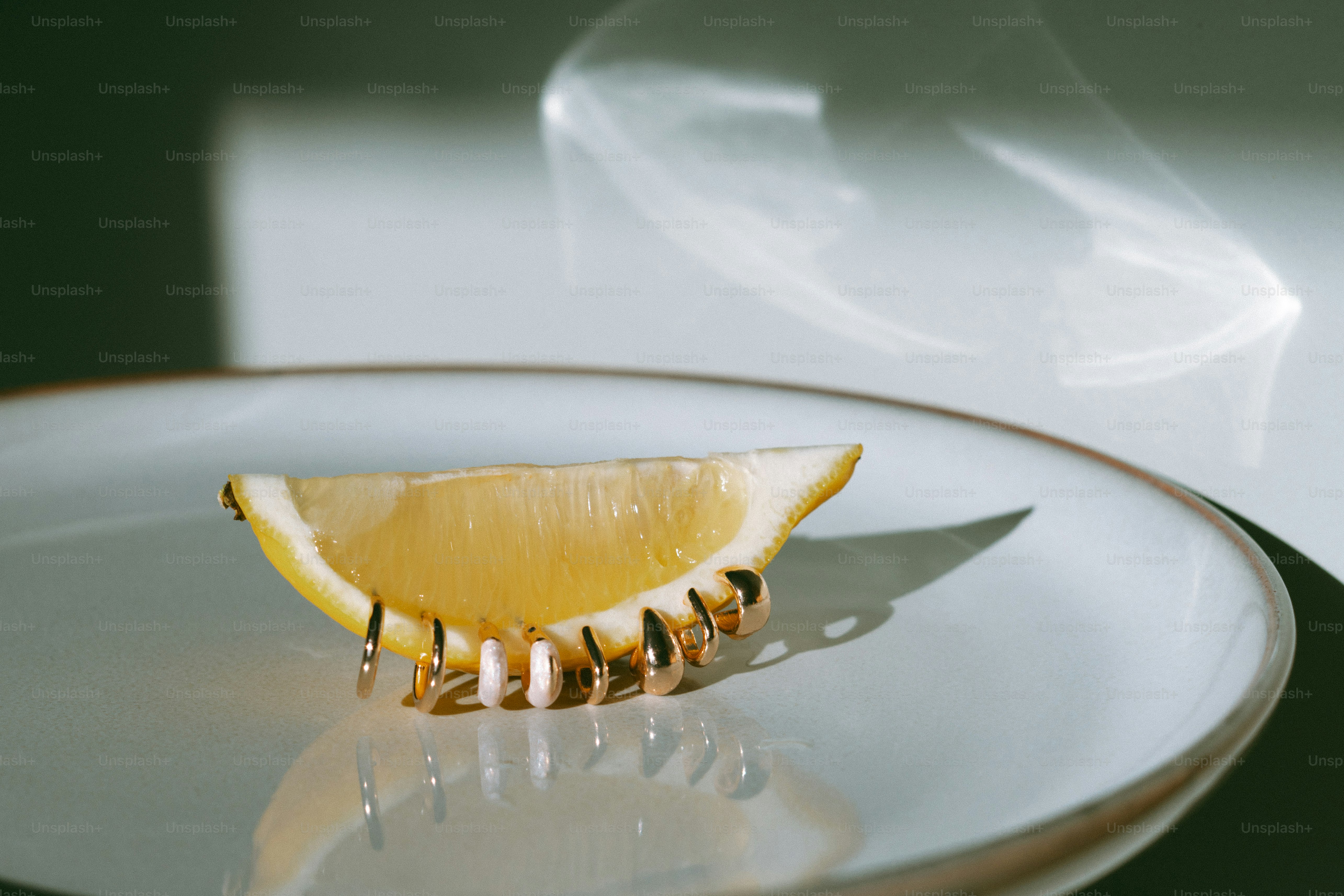 A lemon slice is held by a golden hair clip.