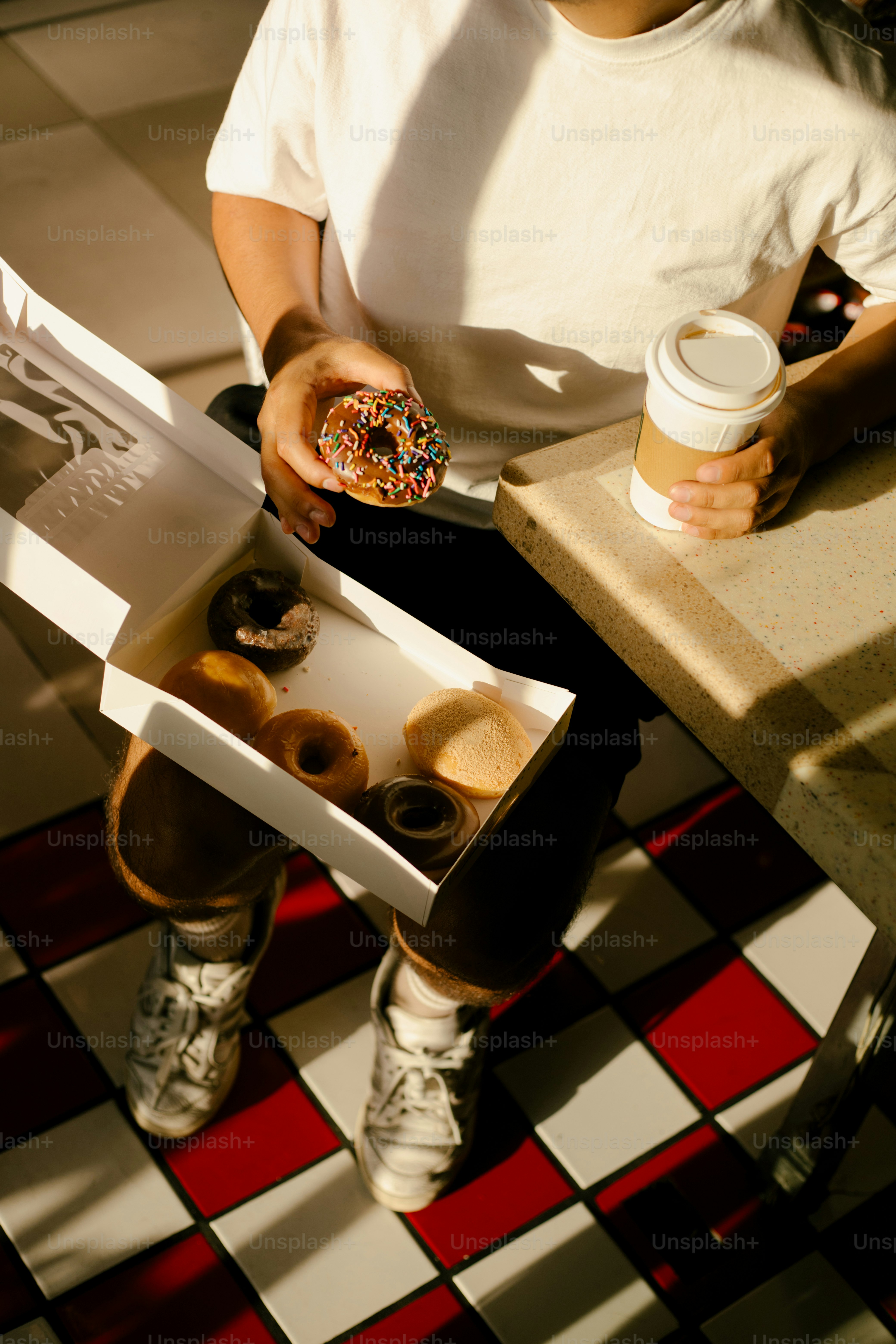Person is enjoying donuts and coffee.