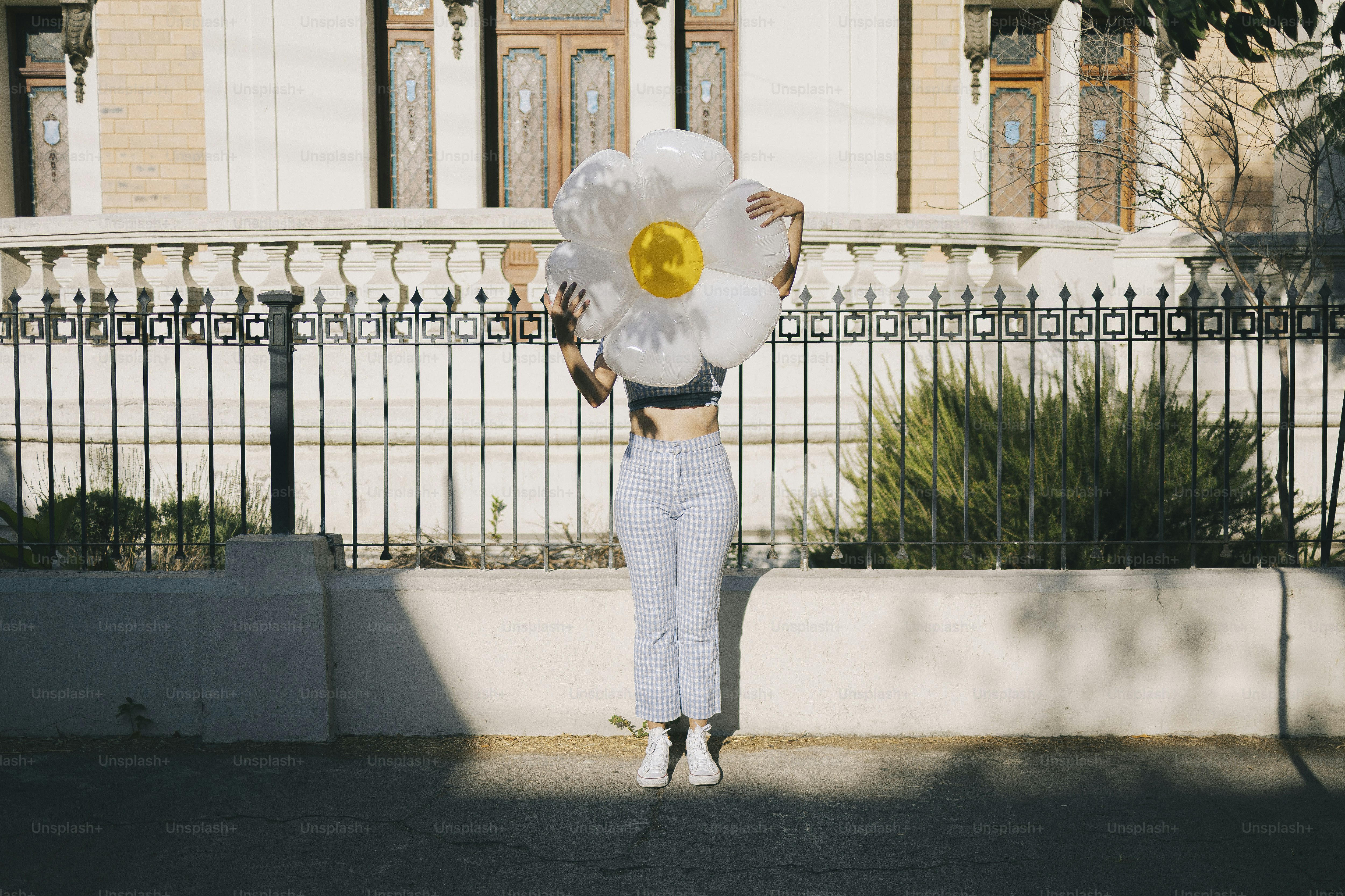 Une personne tient une fleur au-dessus de sa tête.