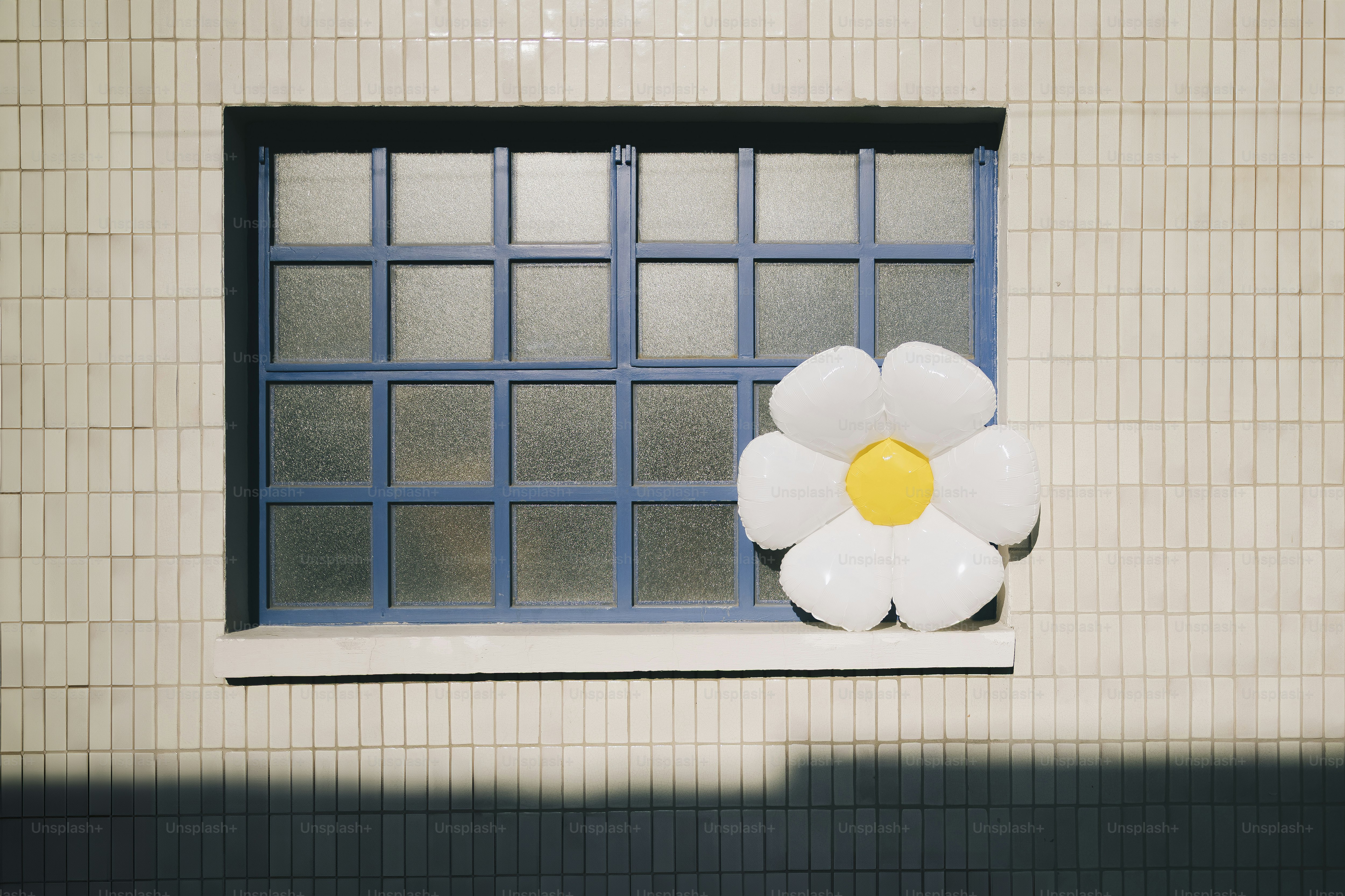 Une fenêtre avec une décoration florale sur le rebord de la fenêtre.