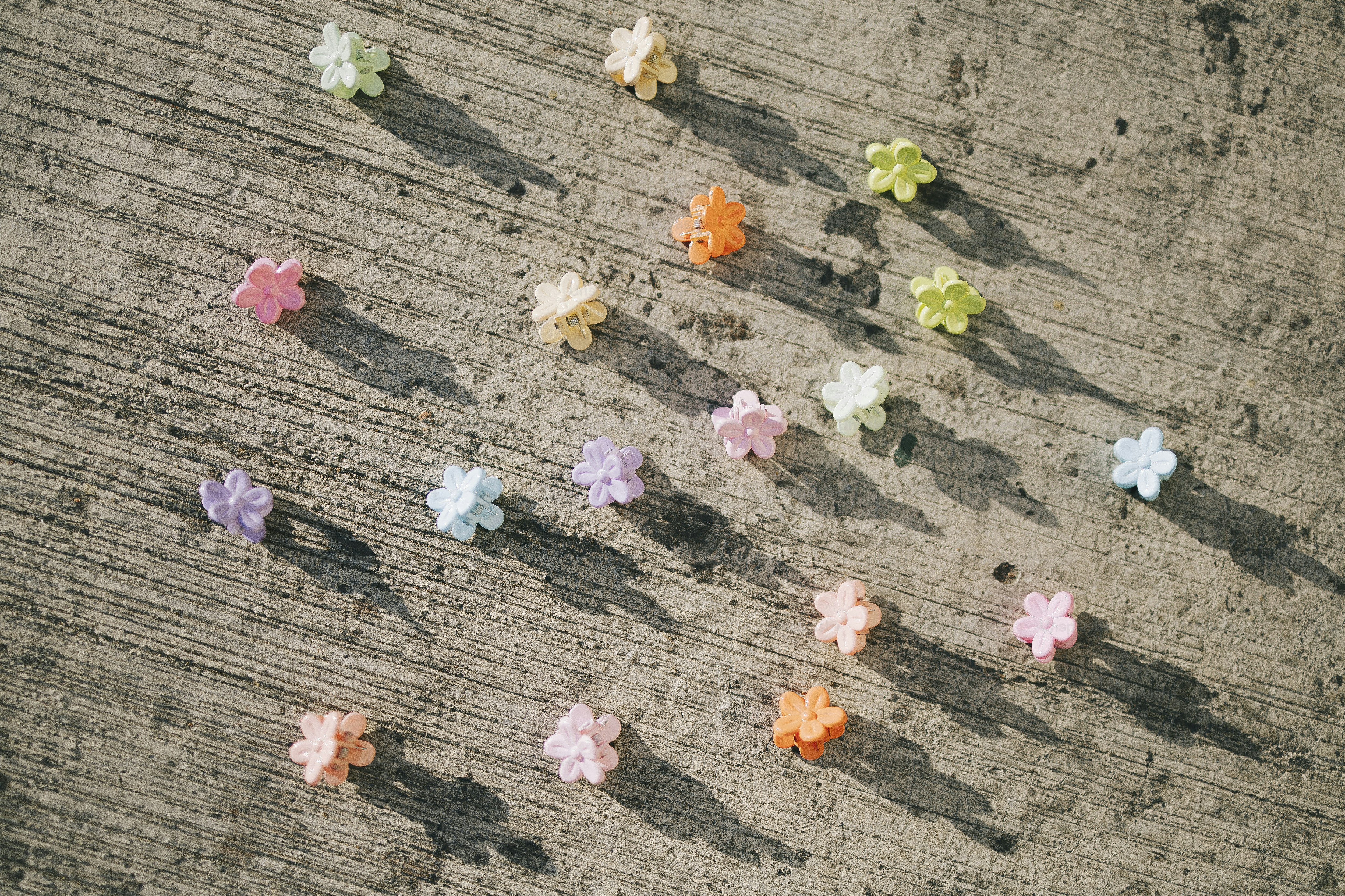 Des bonbons colorés en forme d’étoile se trouvent sur une surface en béton.