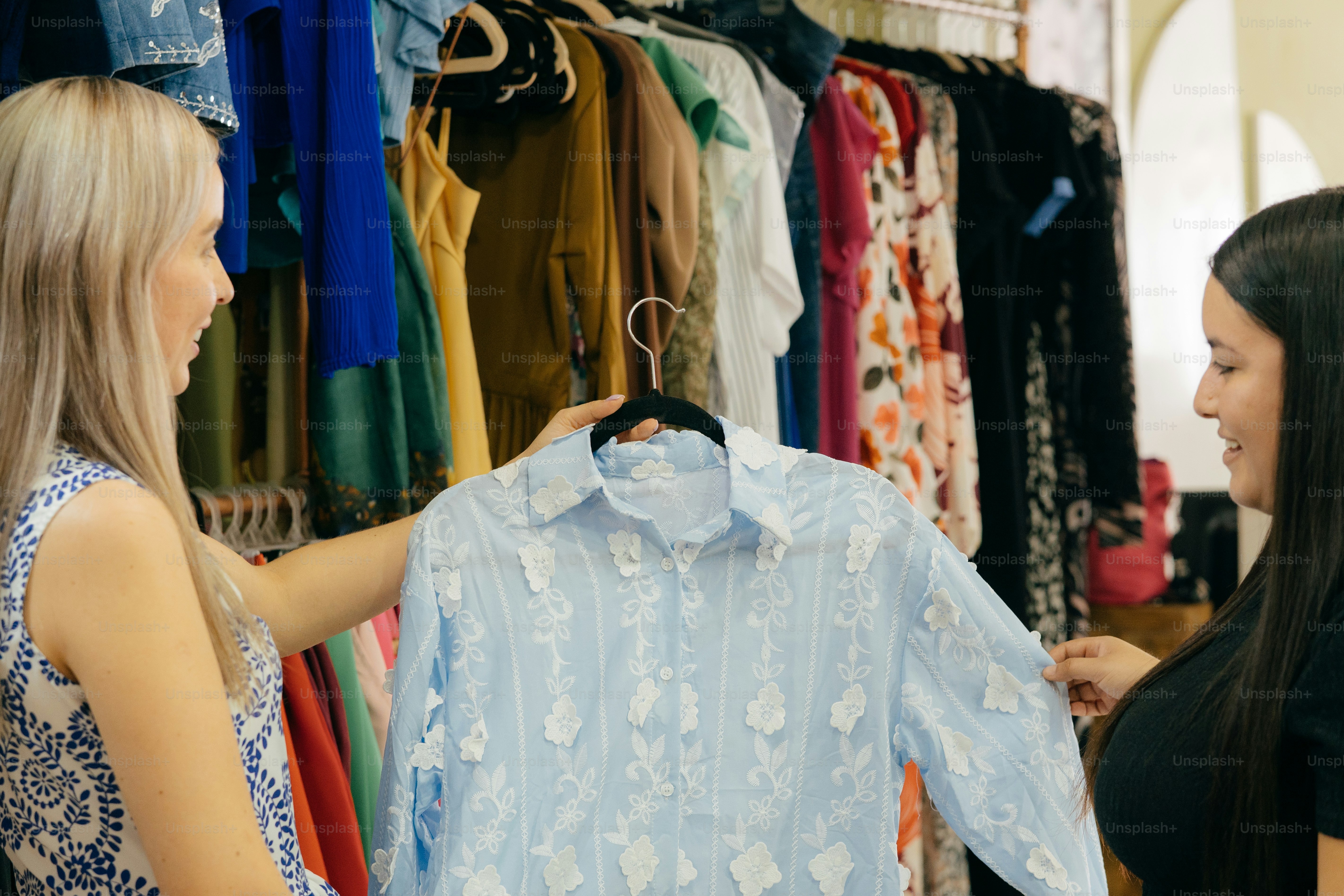Two women shop for clothing in a boutique.
