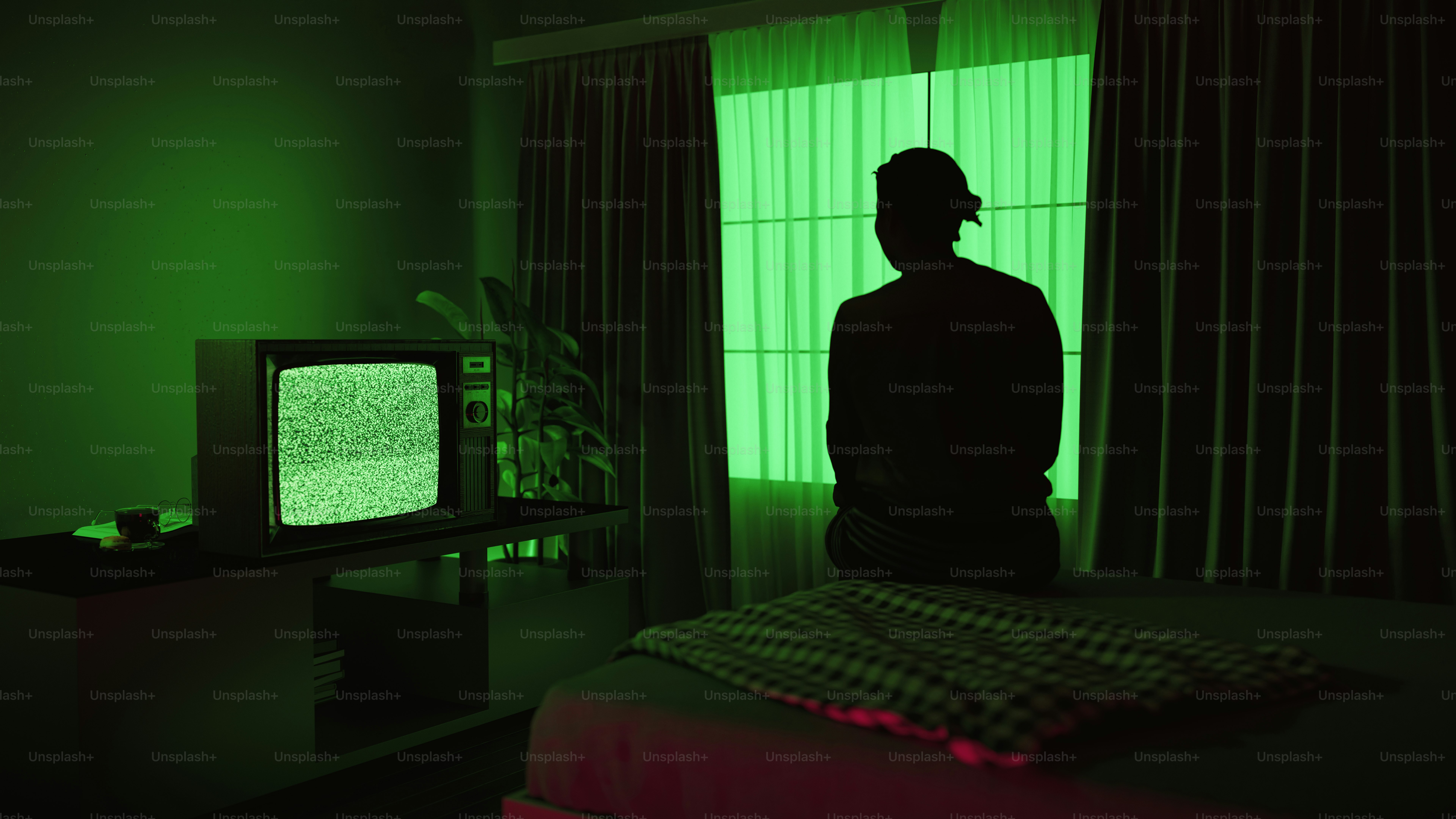A person silhouetted in a green-lit room.