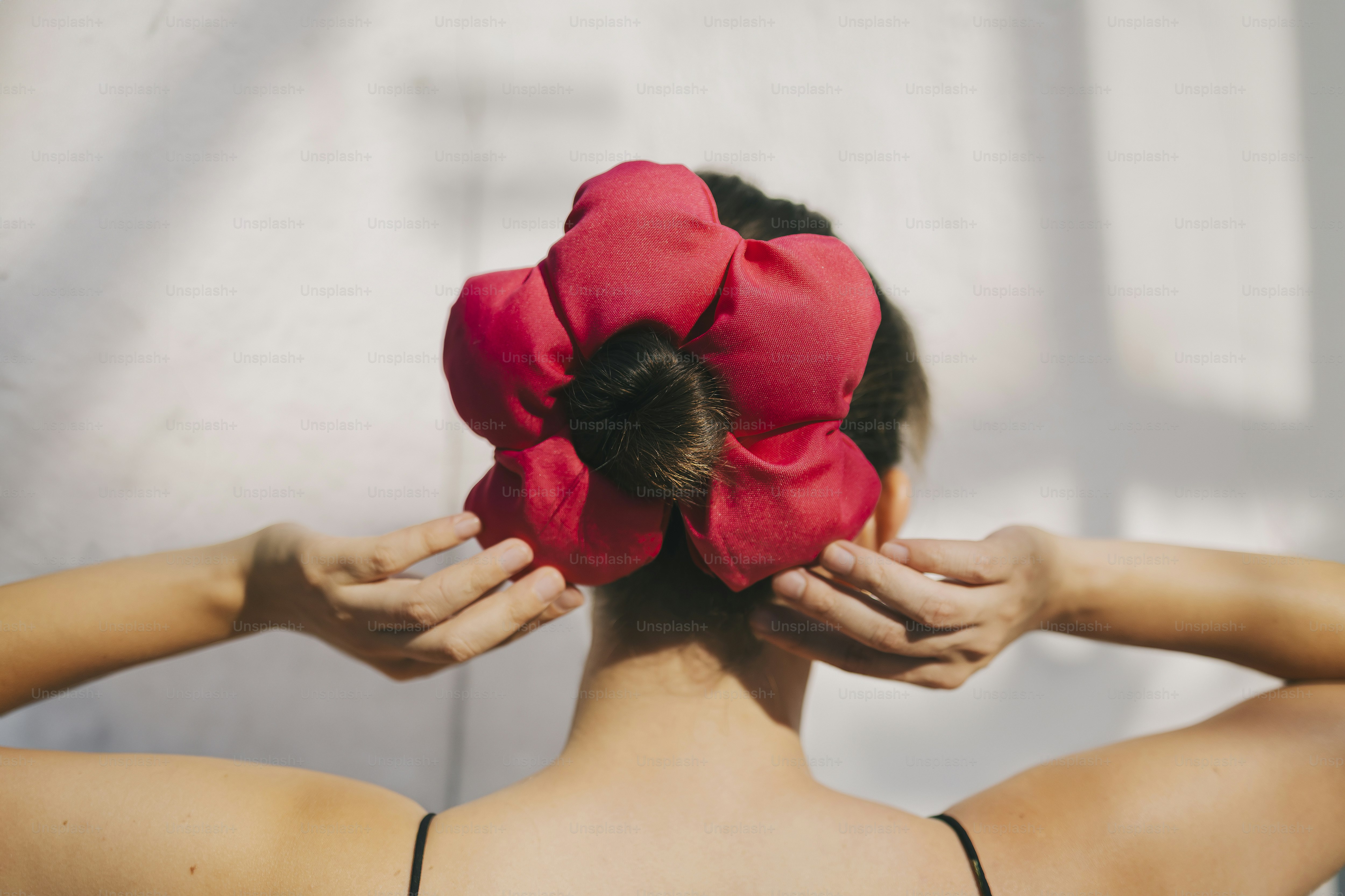 Woman with pink flower hair bun.