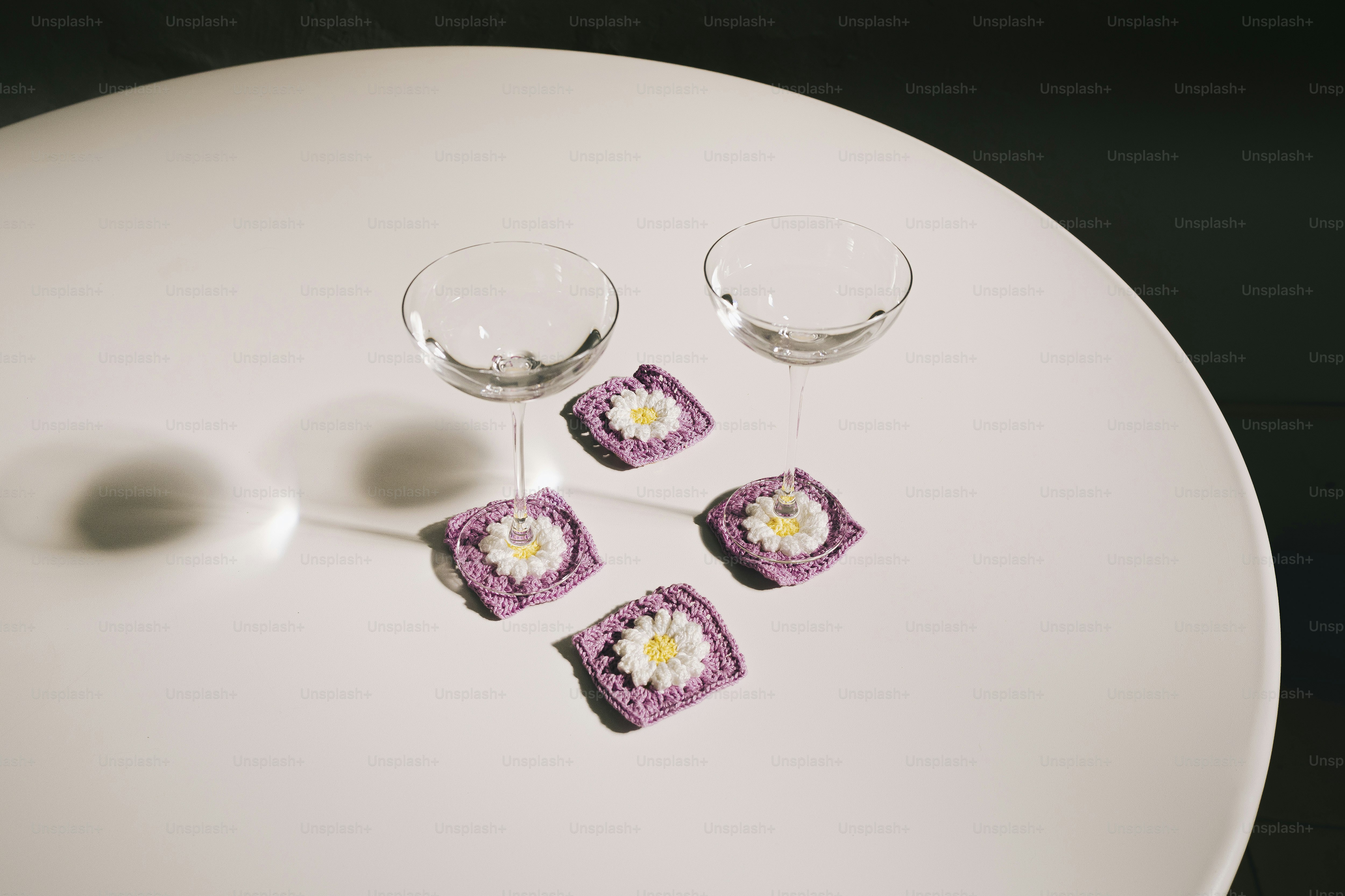 Two wine glasses sit on a white table.