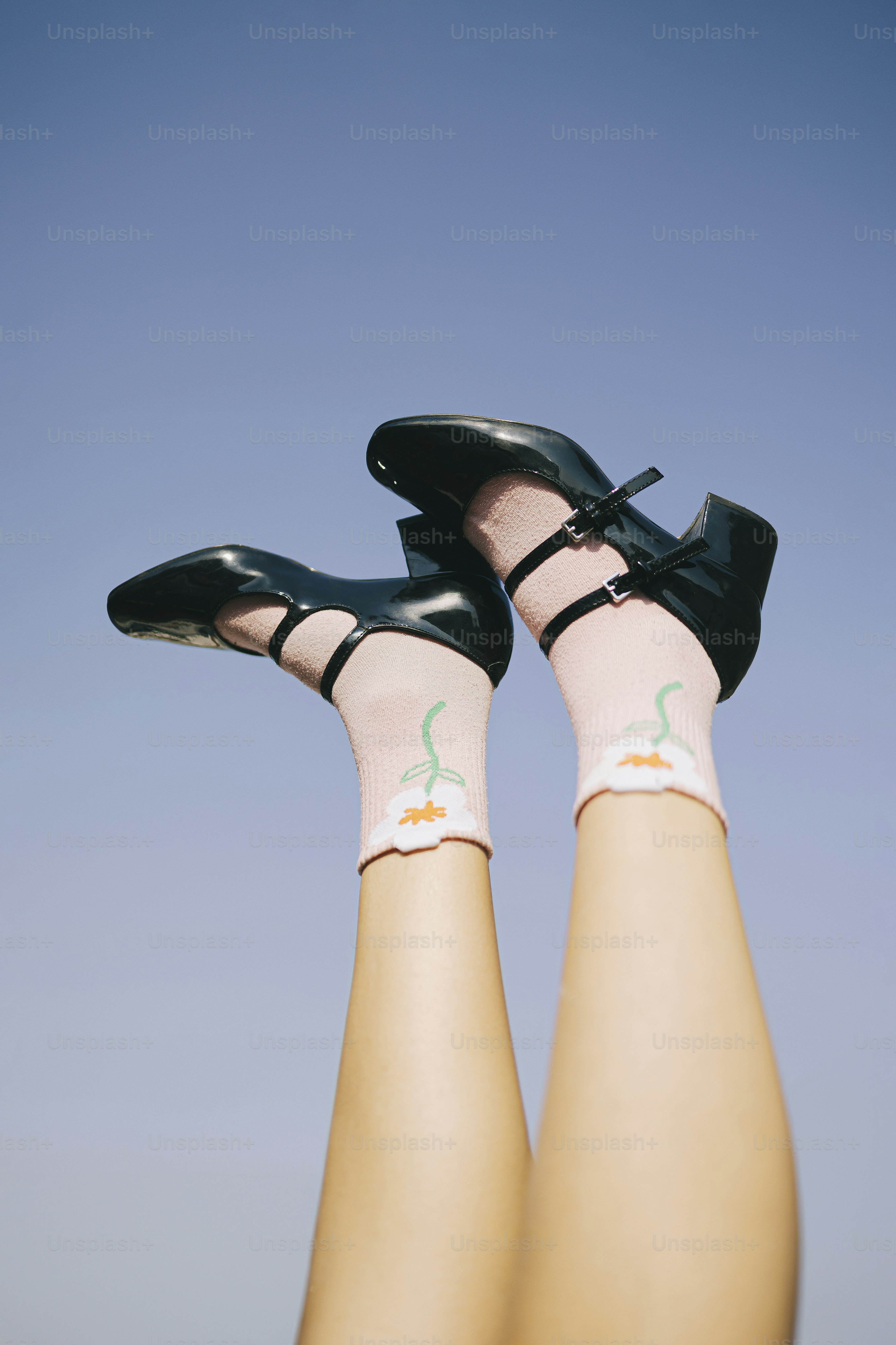 Feet in the air, showing off shoes and socks.