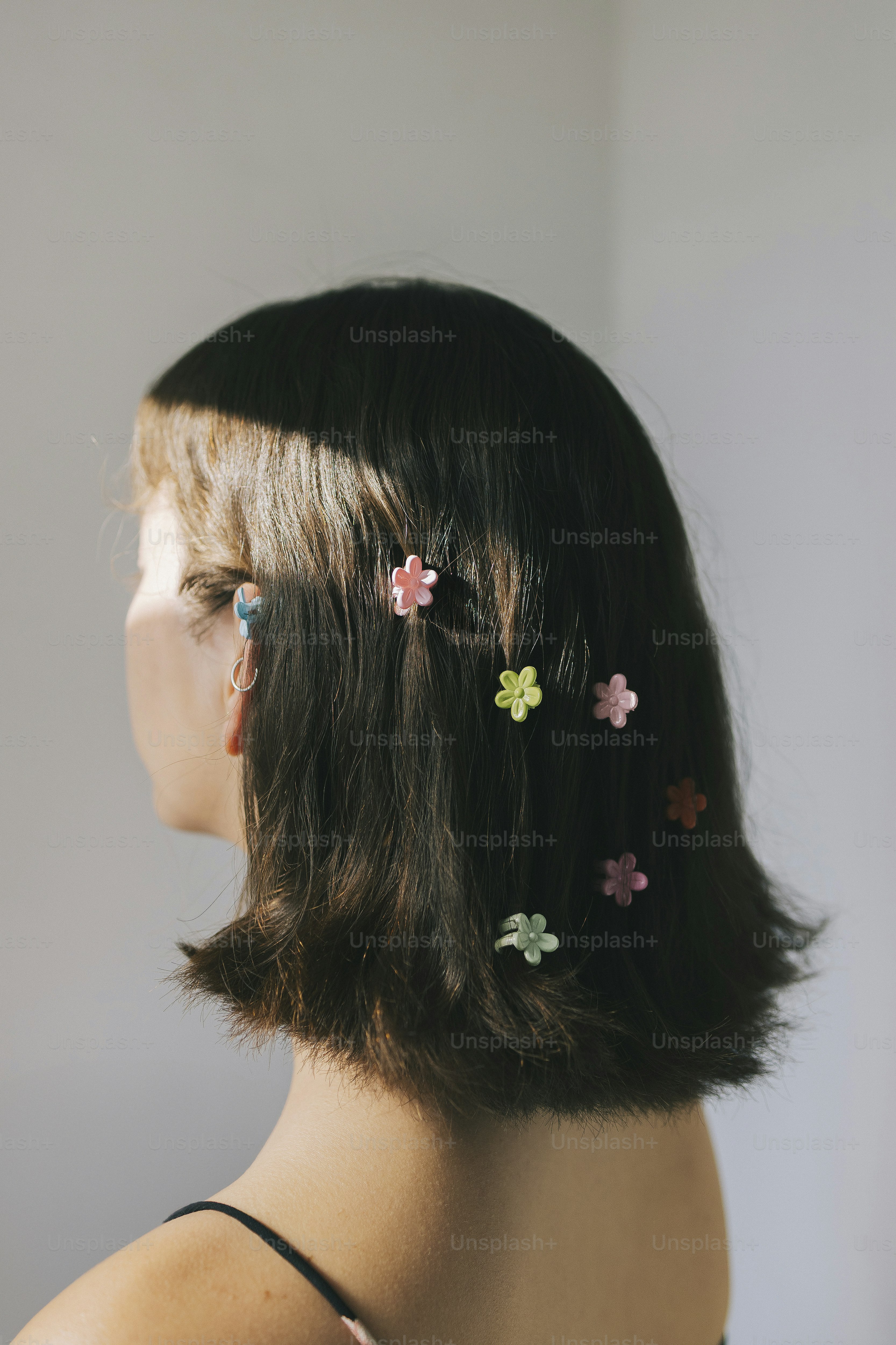 Hair adorned with flower clips.