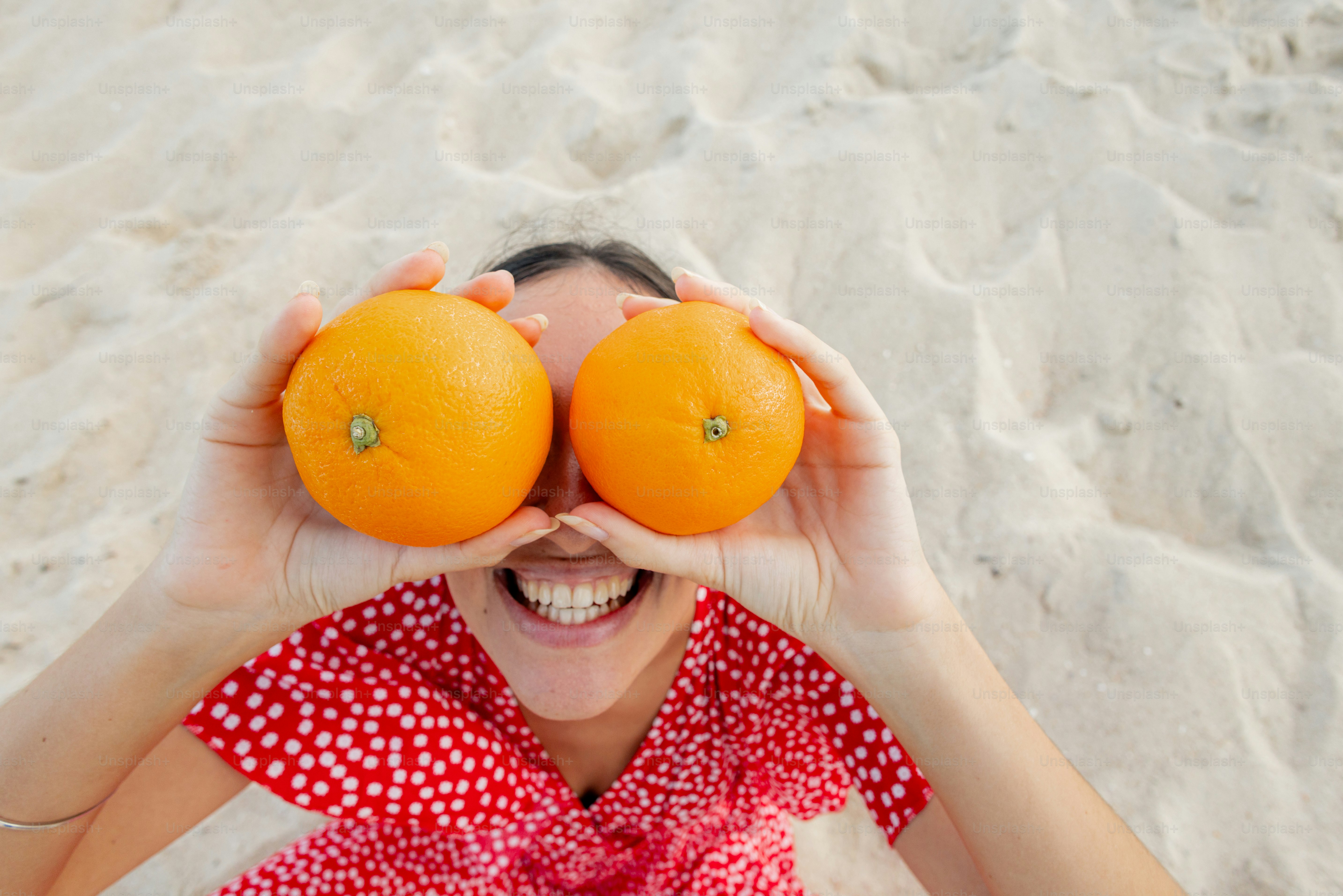 Woman uses oranges to play with her eyes.