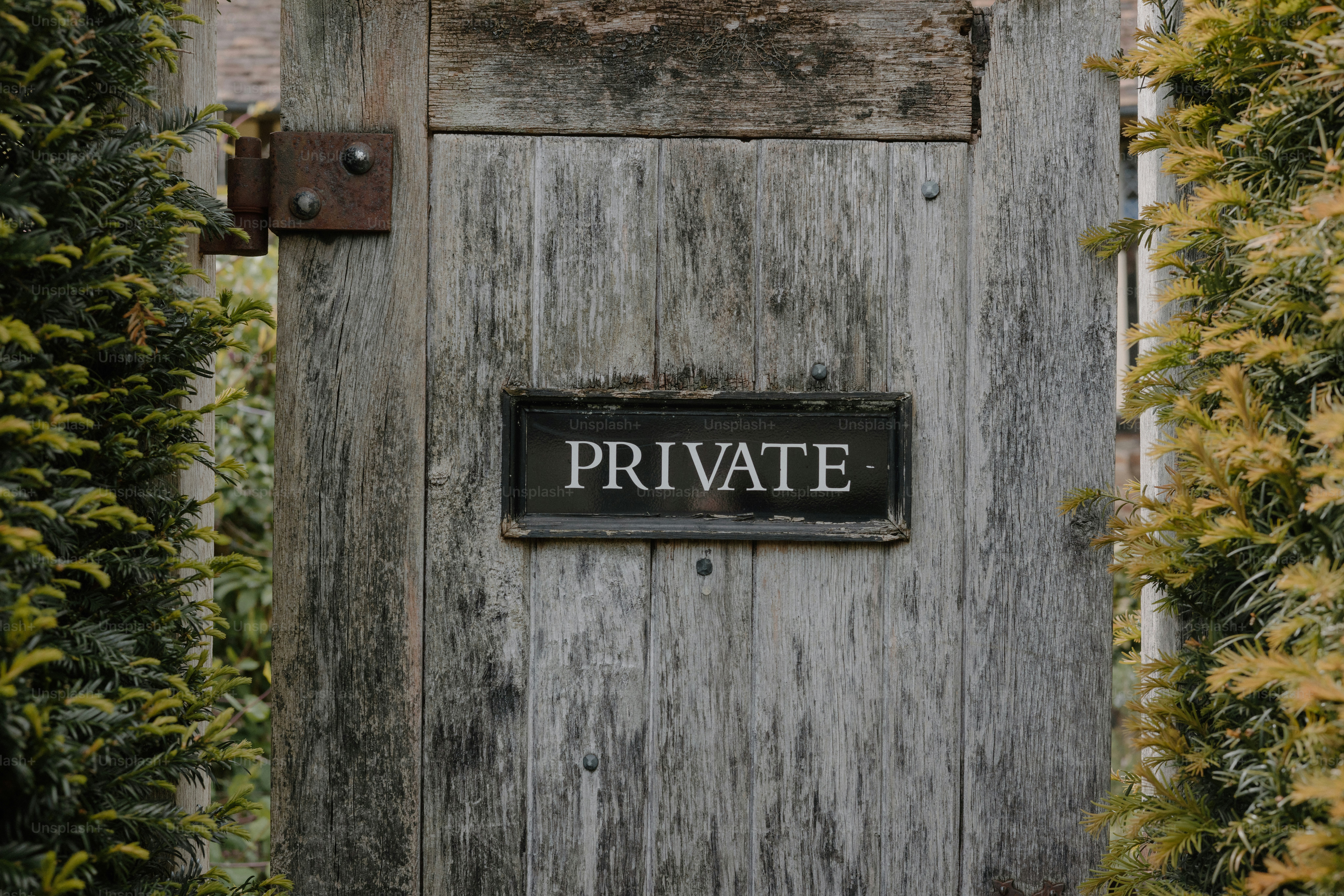 A wooden gate with a private sign.