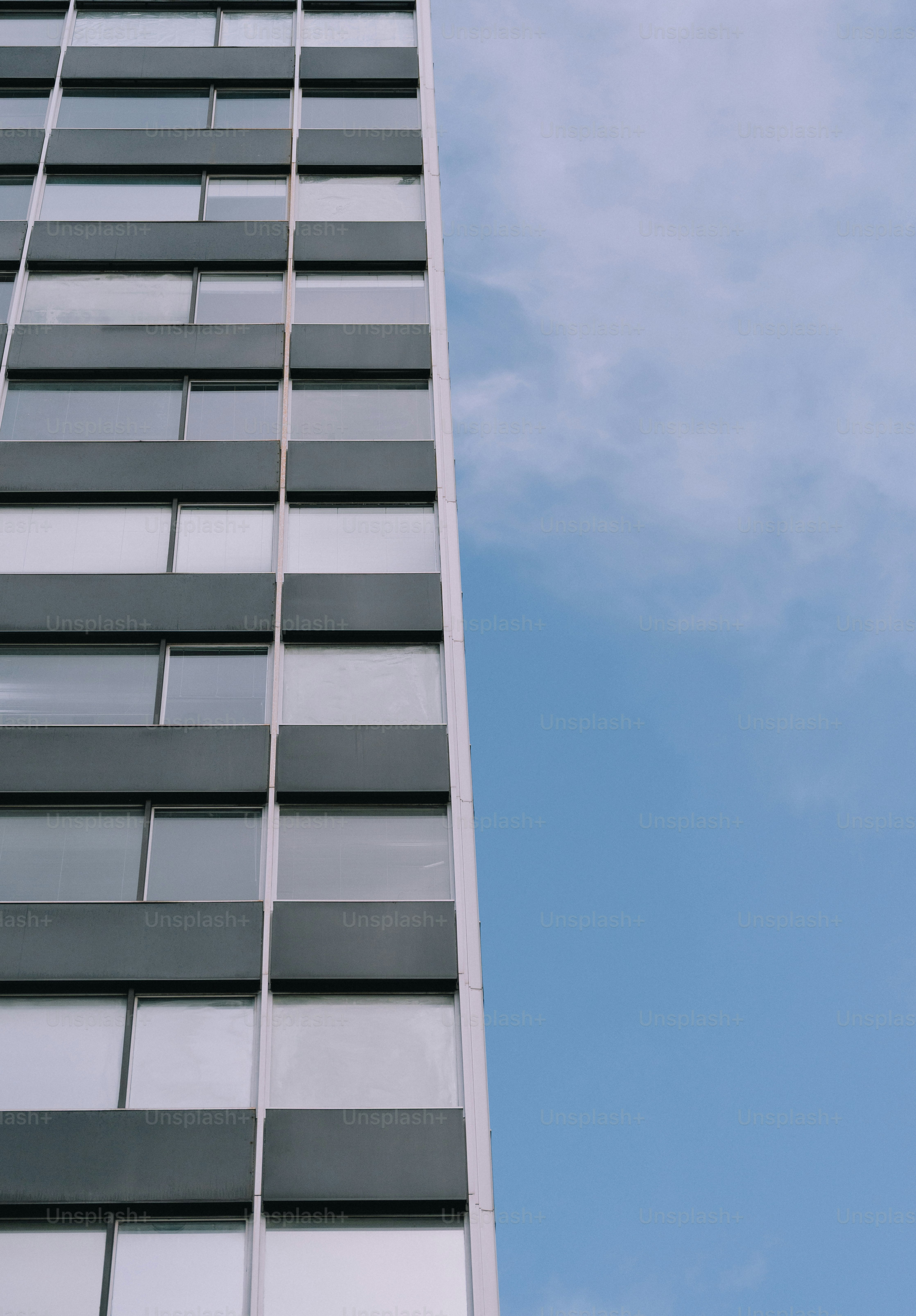 A tall building reaches towards the blue sky.