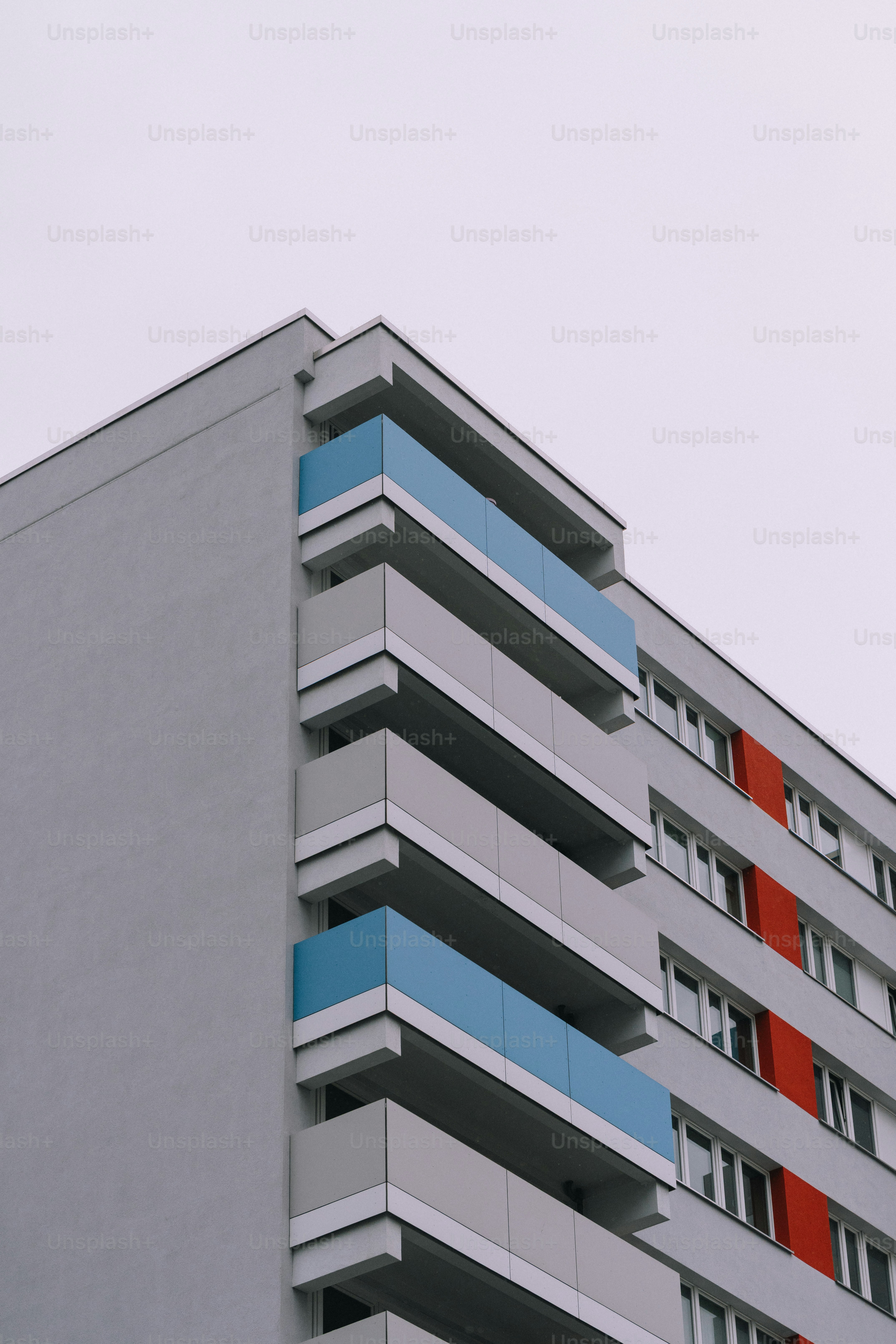 Modern apartment building with red and blue accents.