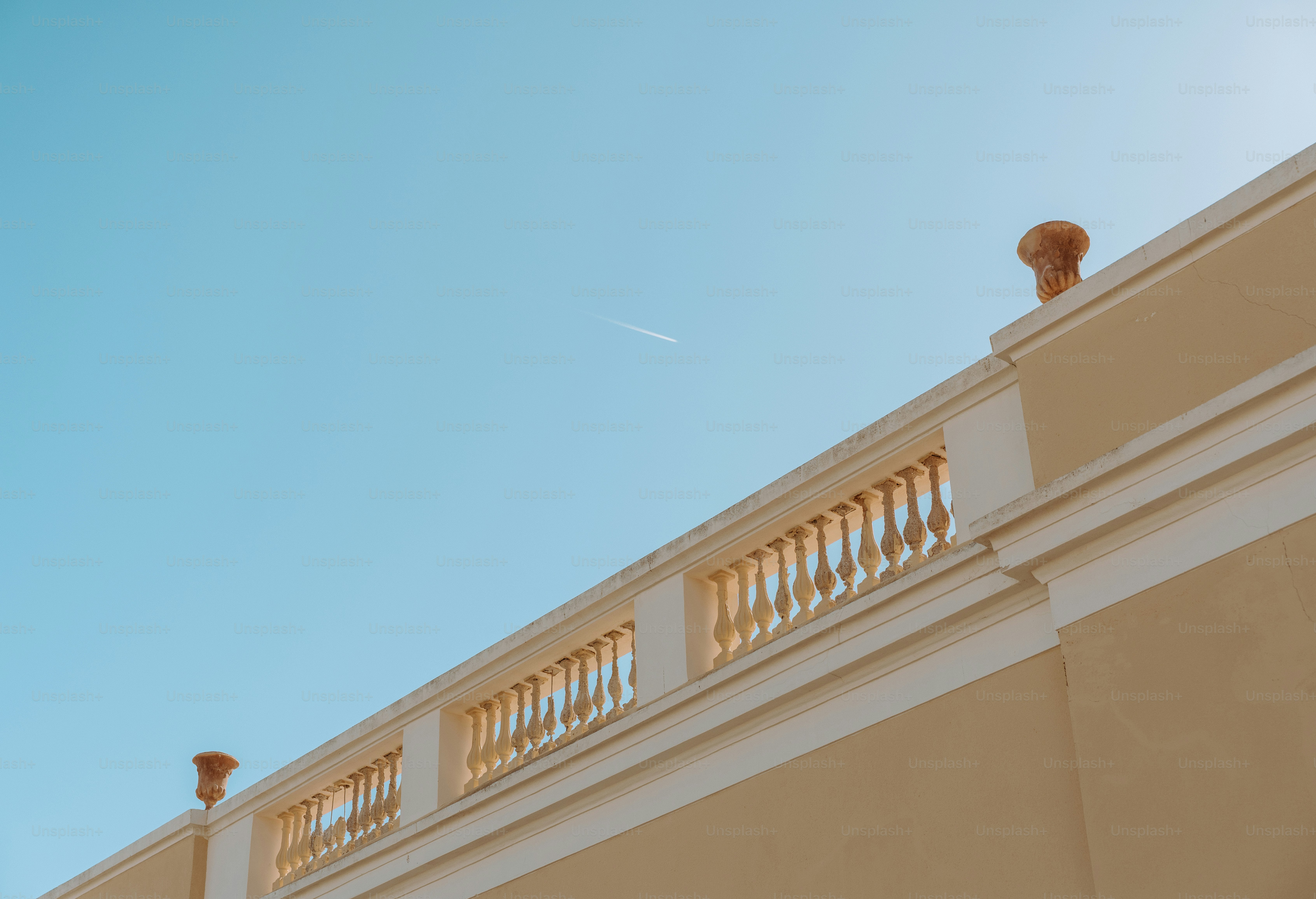 Rooftop railing against a bright, blue sky.