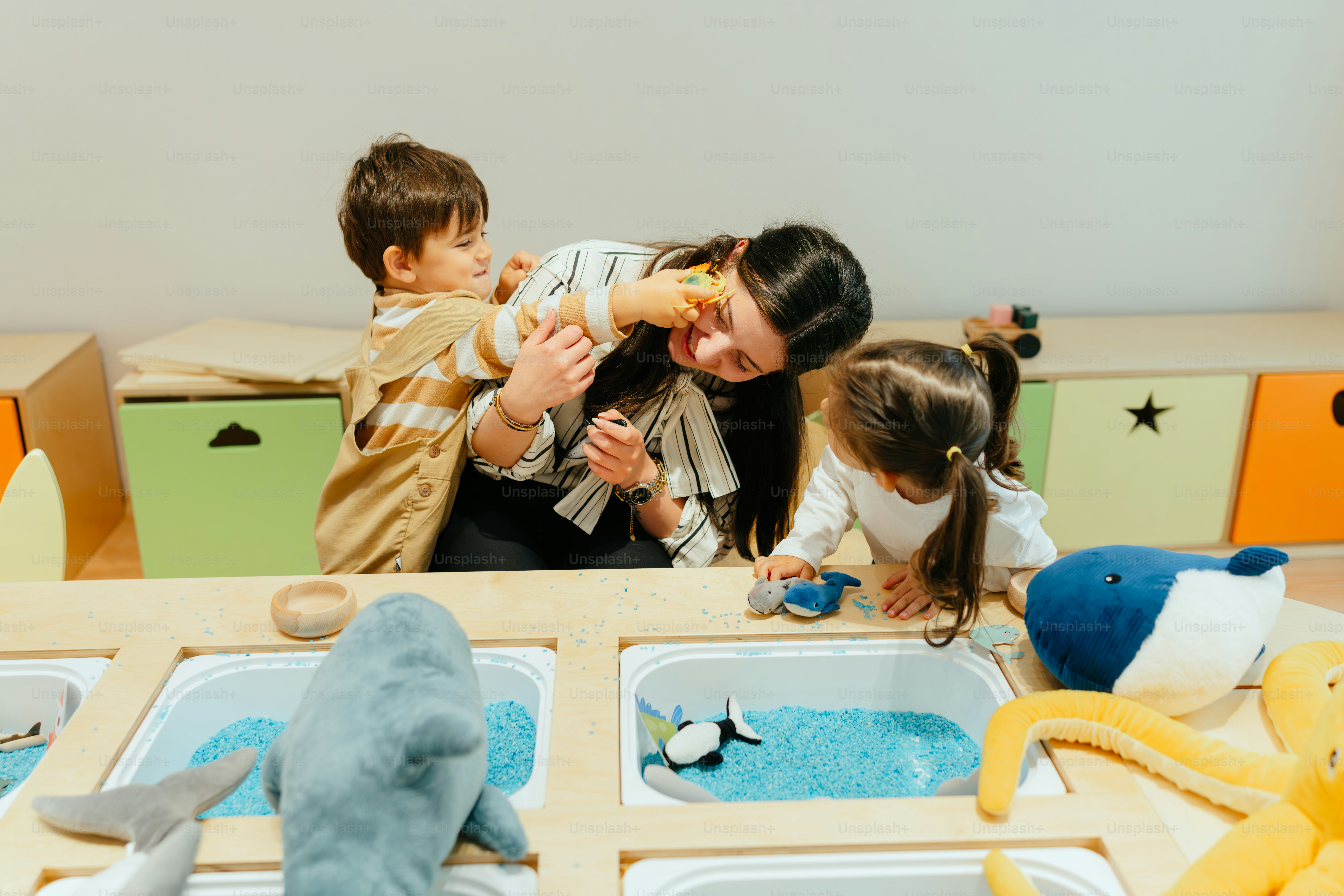 Children play together, including a teacher.