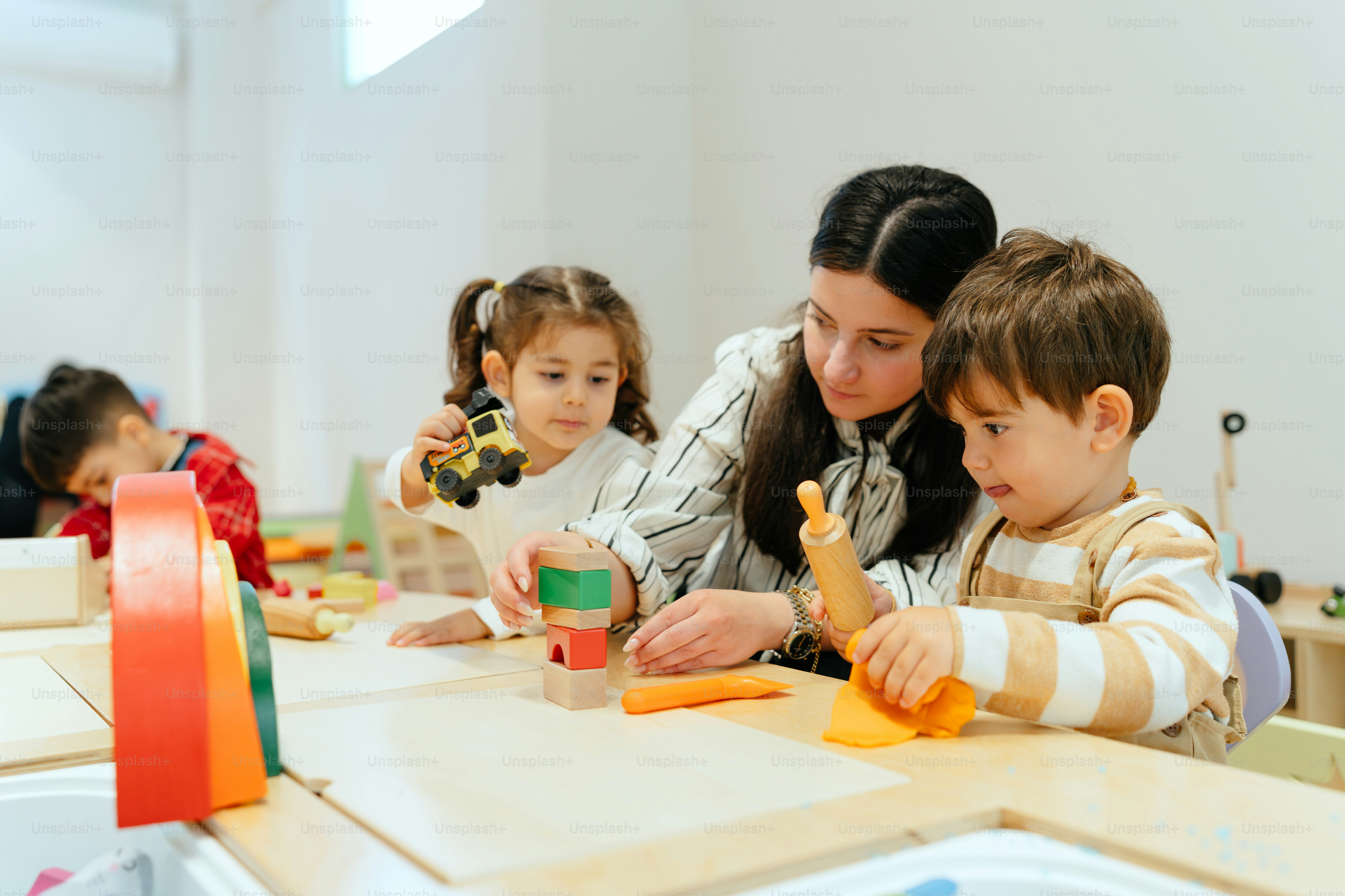 Children and a teacher play with blocks.
