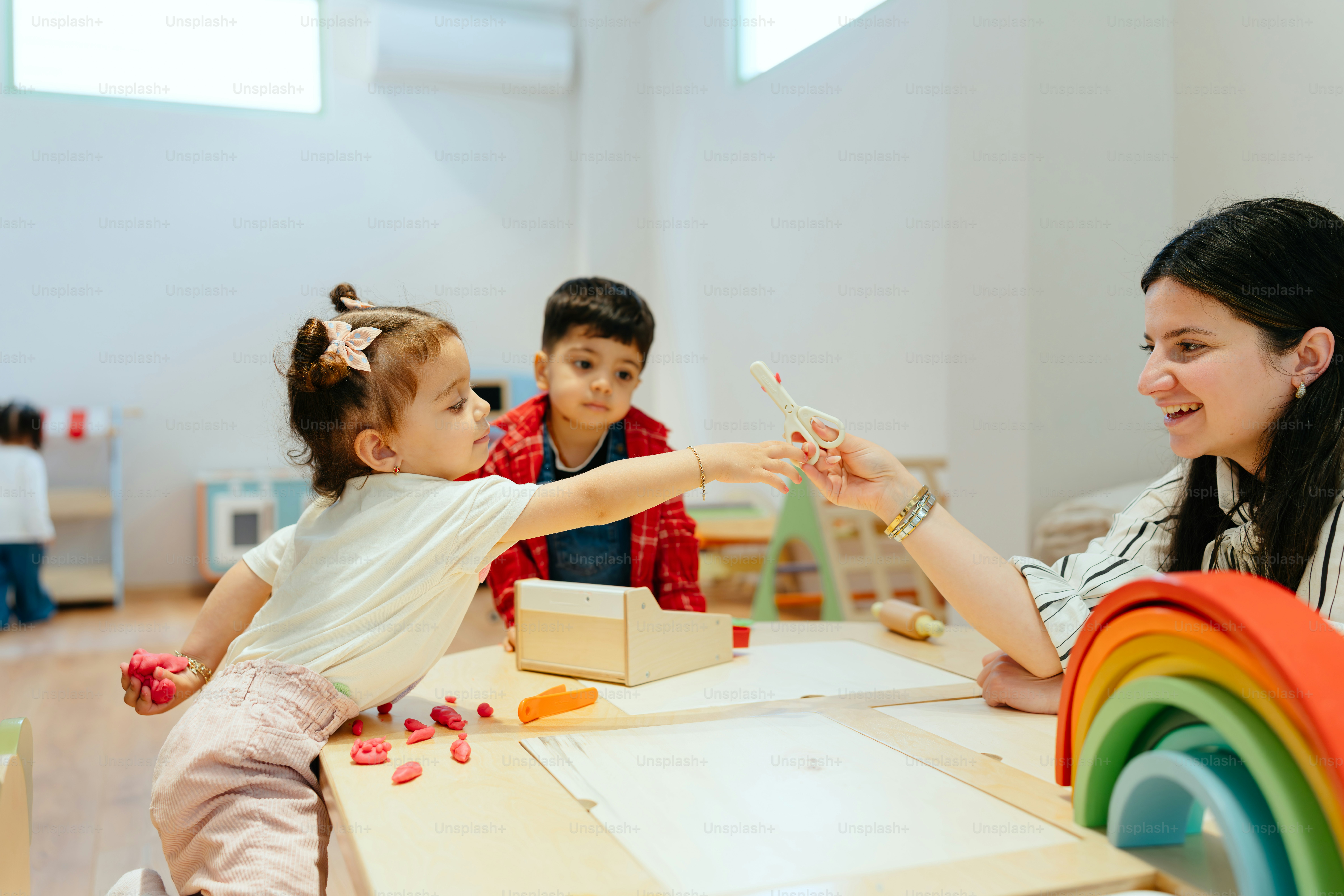 A teacher plays with children in a classroom.