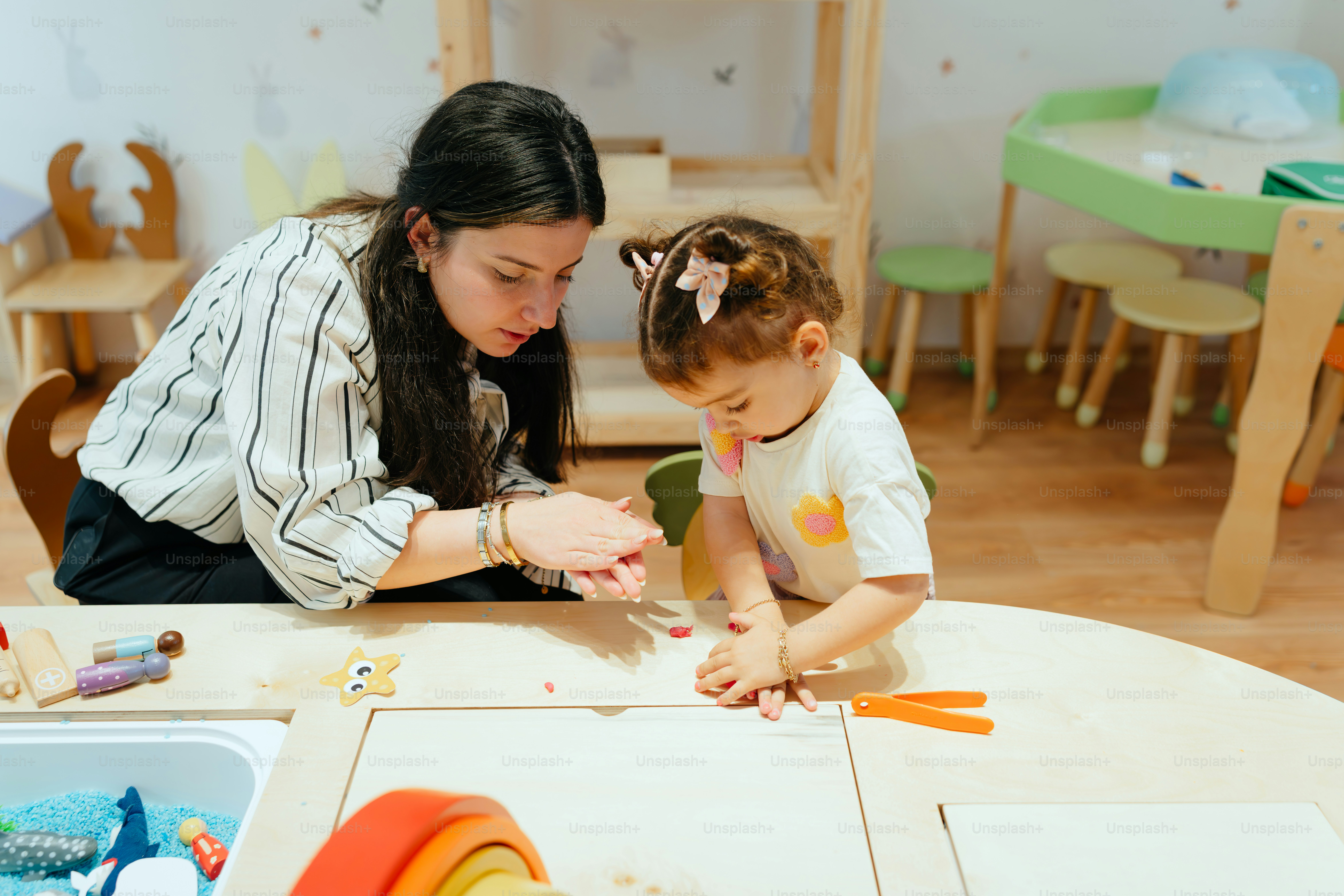 A teacher is helping a child with an activity.