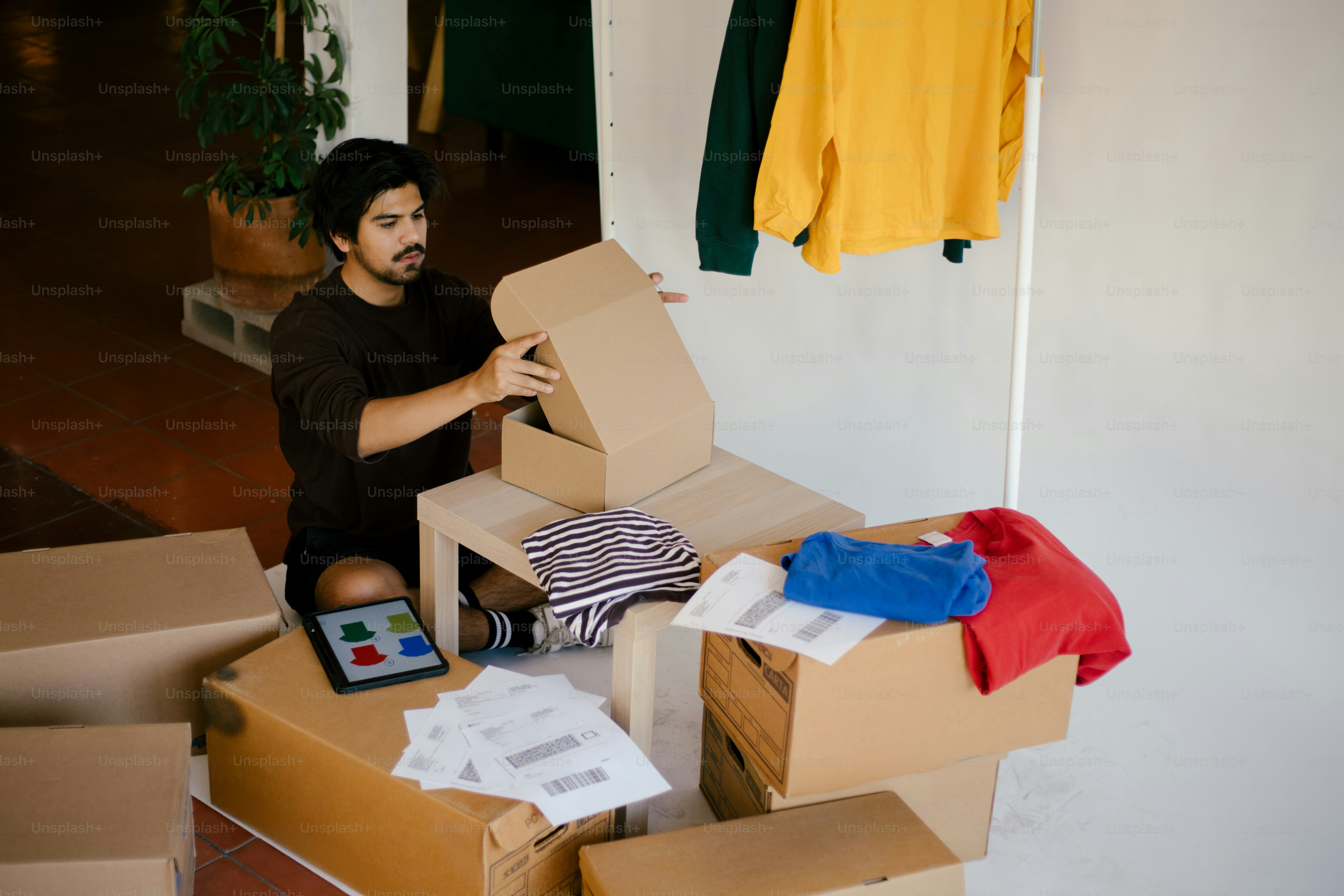 Man sorts through packages next to clothes.