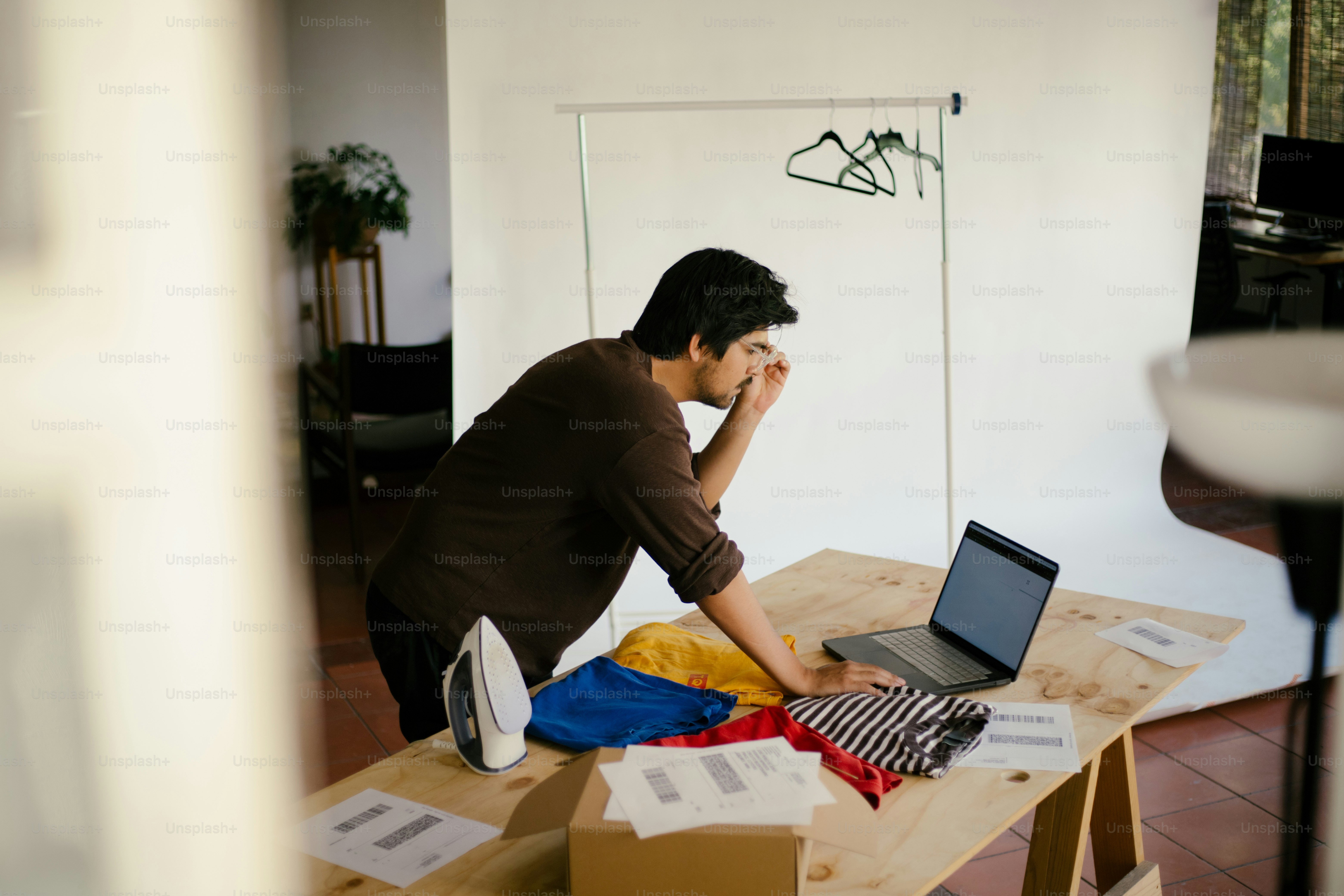 Man reviews laptop with clothes and an iron.