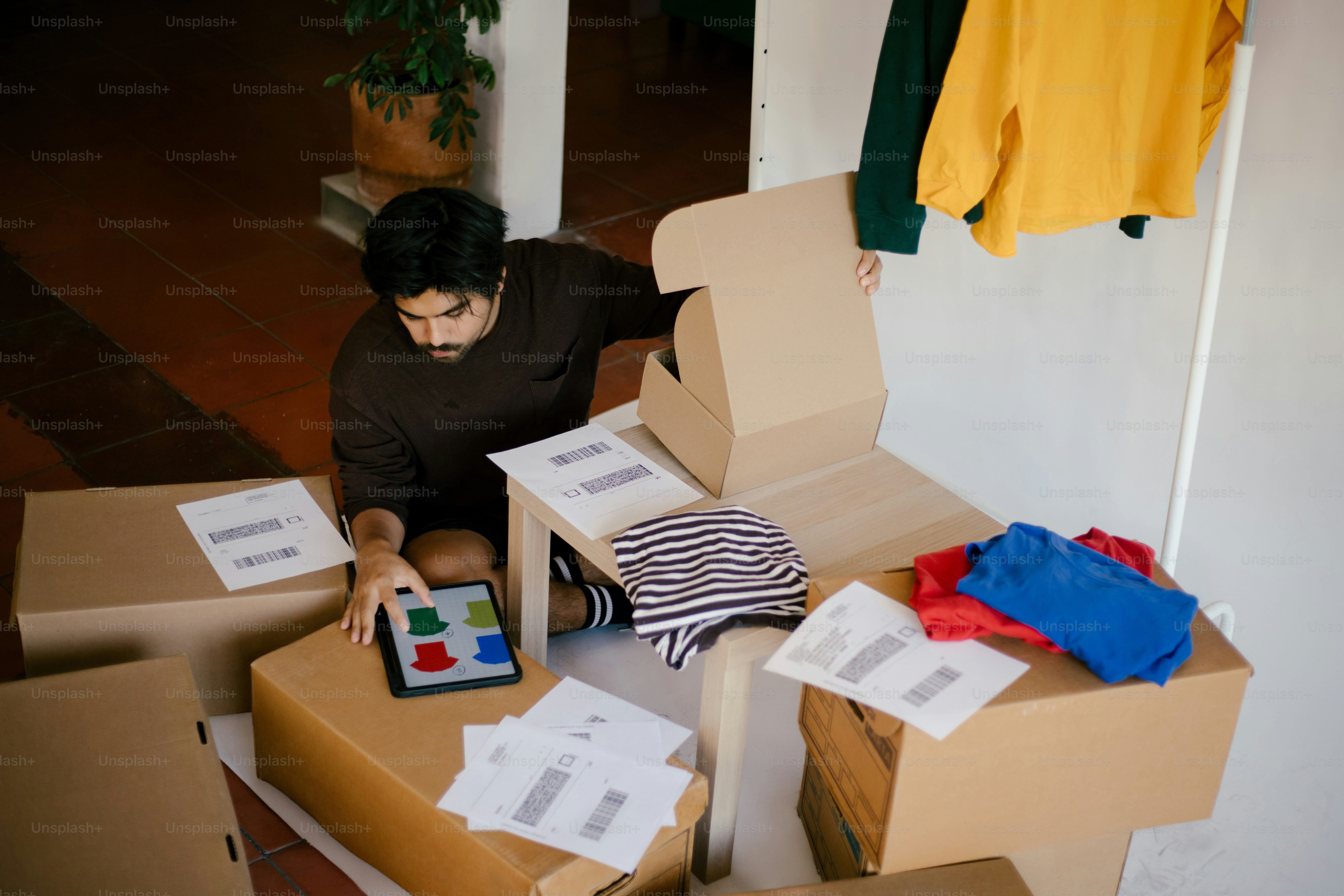 A man organizes clothes and packages online.