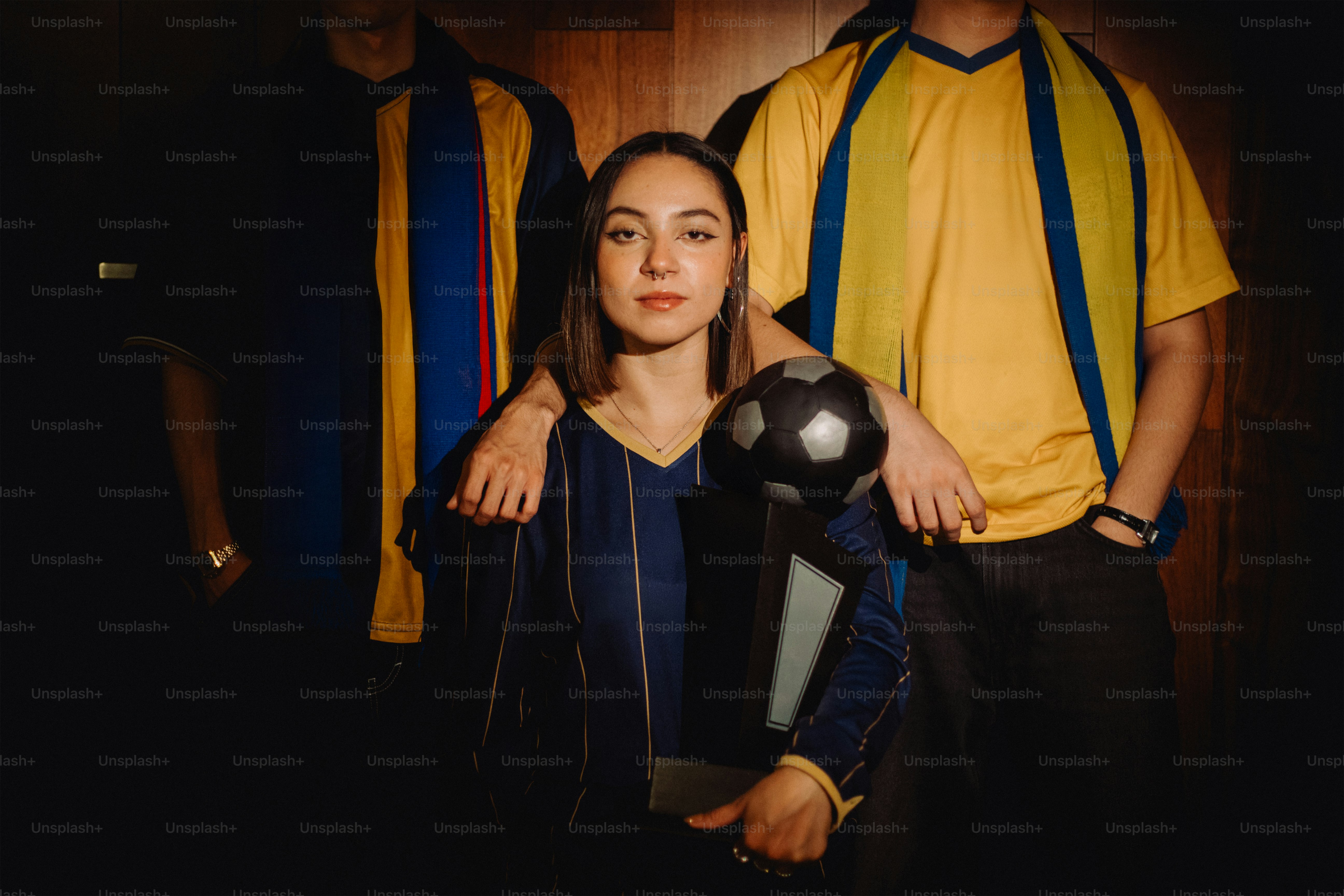 Woman holding a soccer ball with teammates.