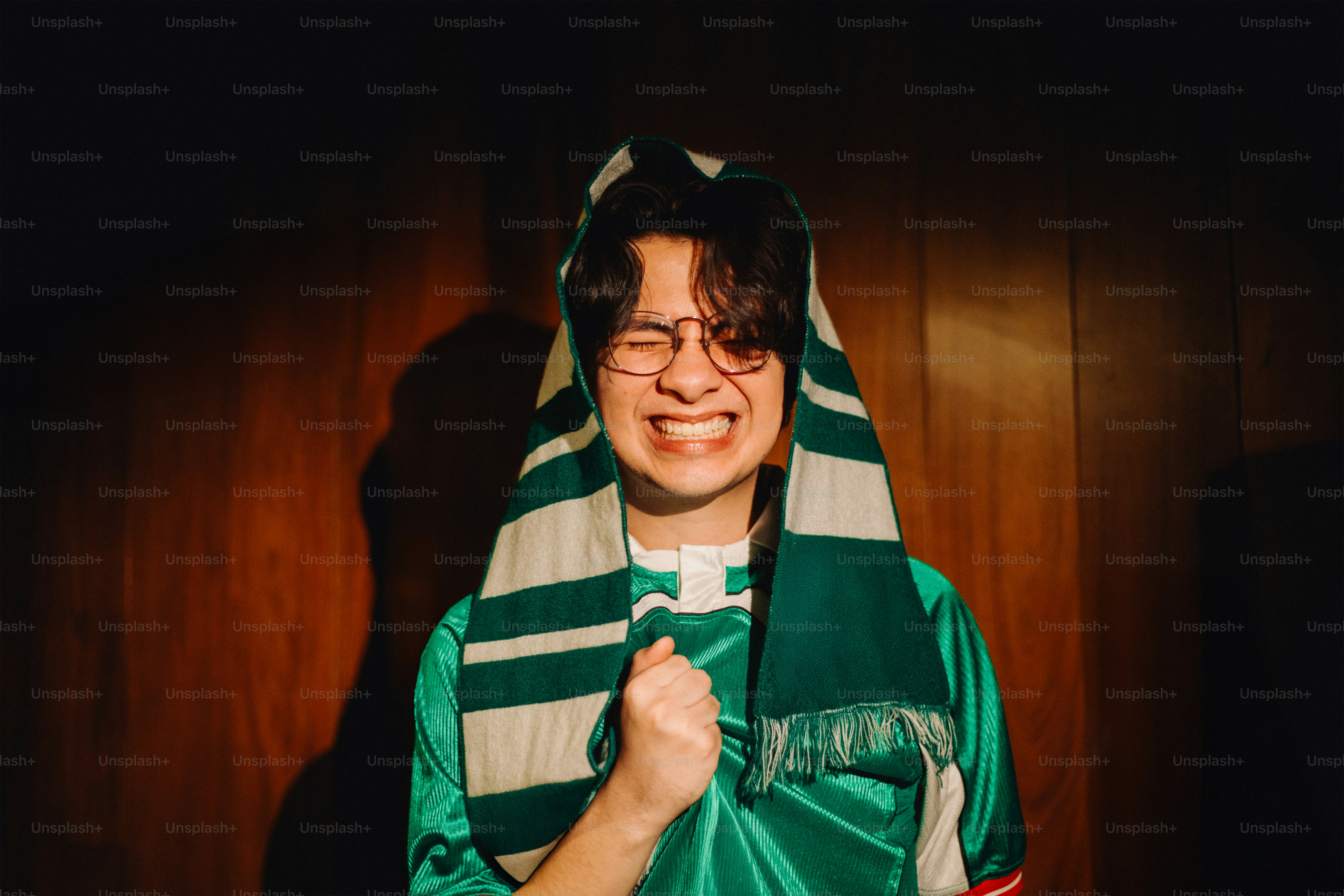 A person with glasses and a scarf makes a face