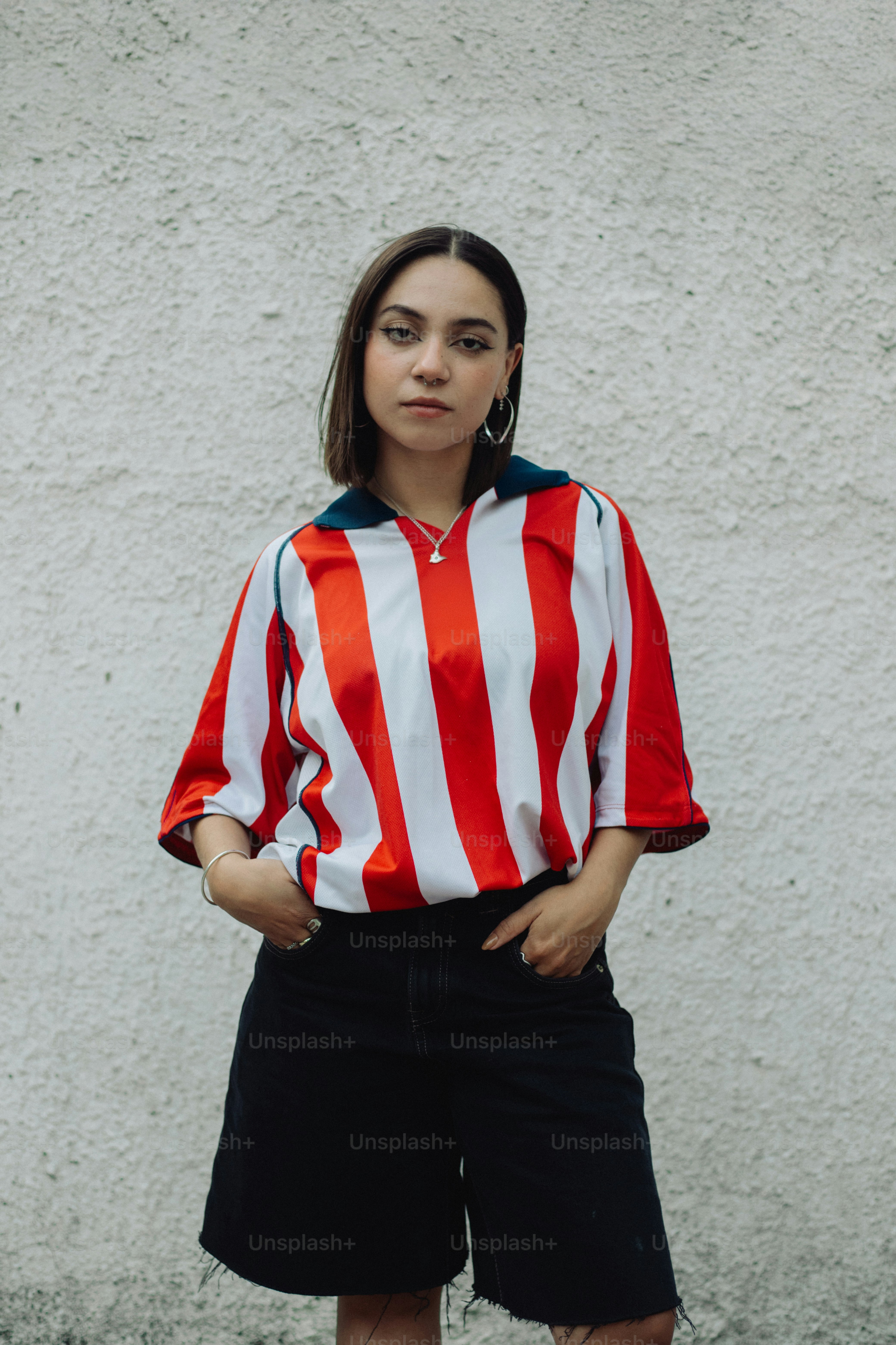 A woman wears a striped shirt and shorts.