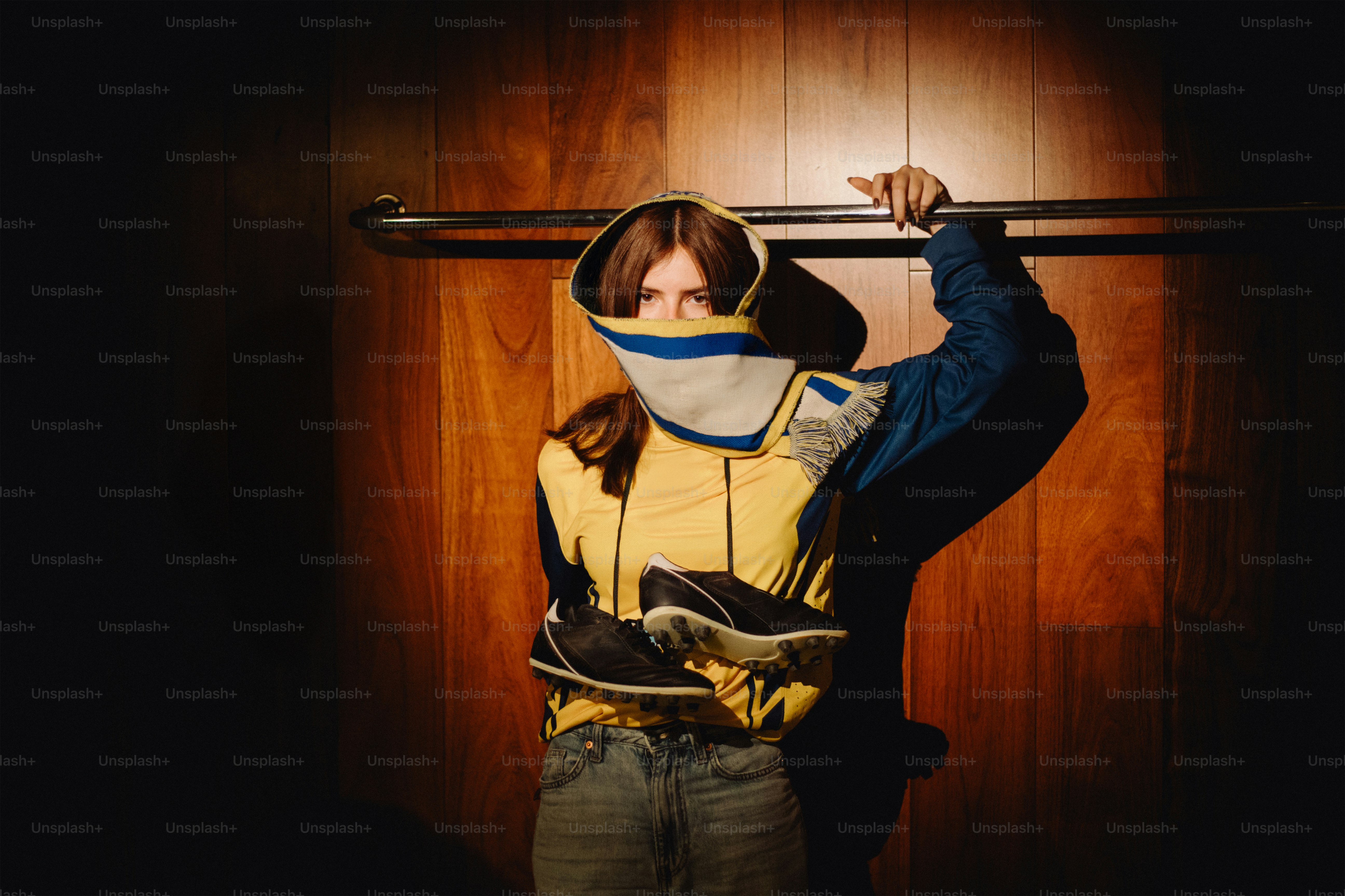 Woman poses with jacket in a dimly lit space
