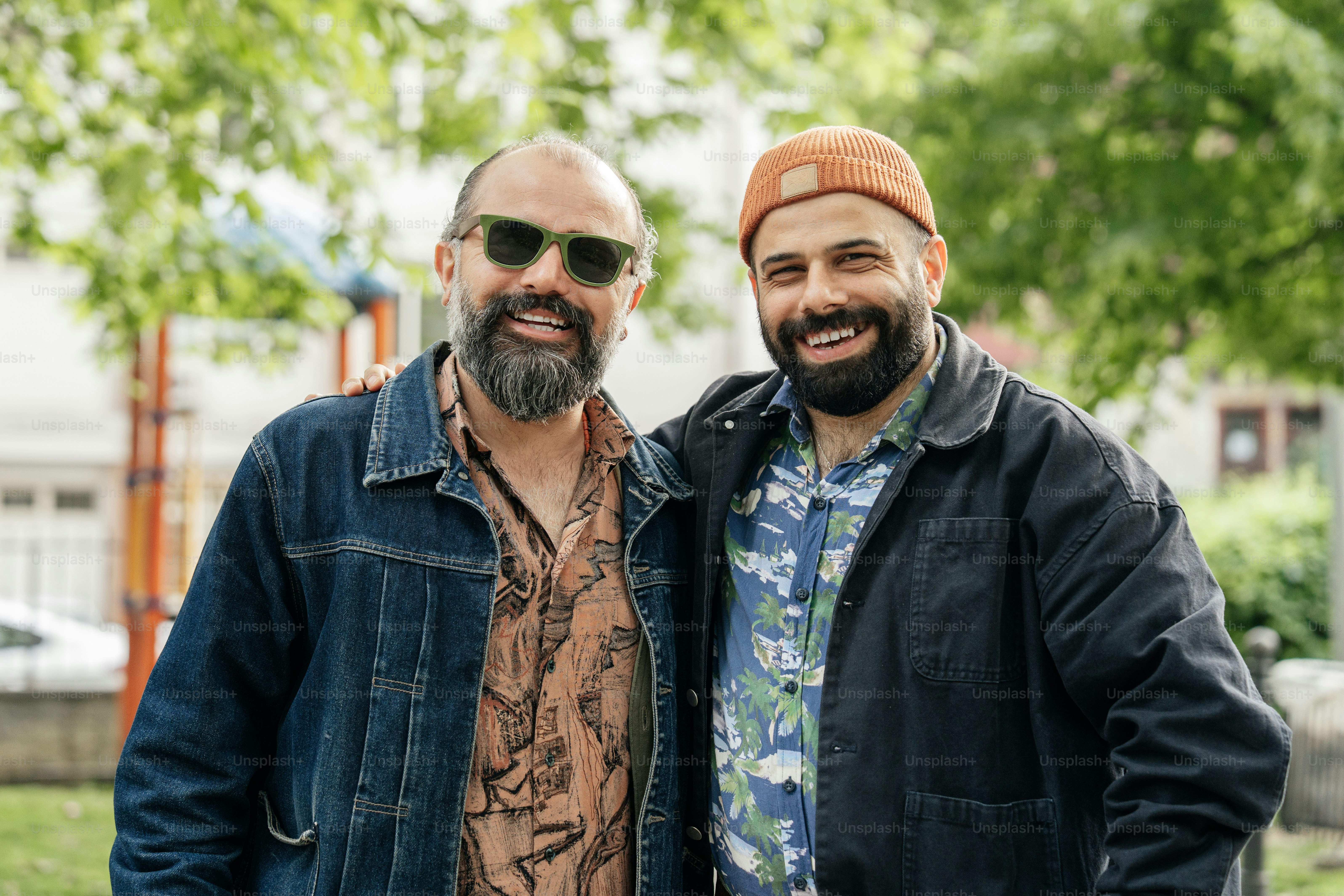 Two men are smiling and posing together.