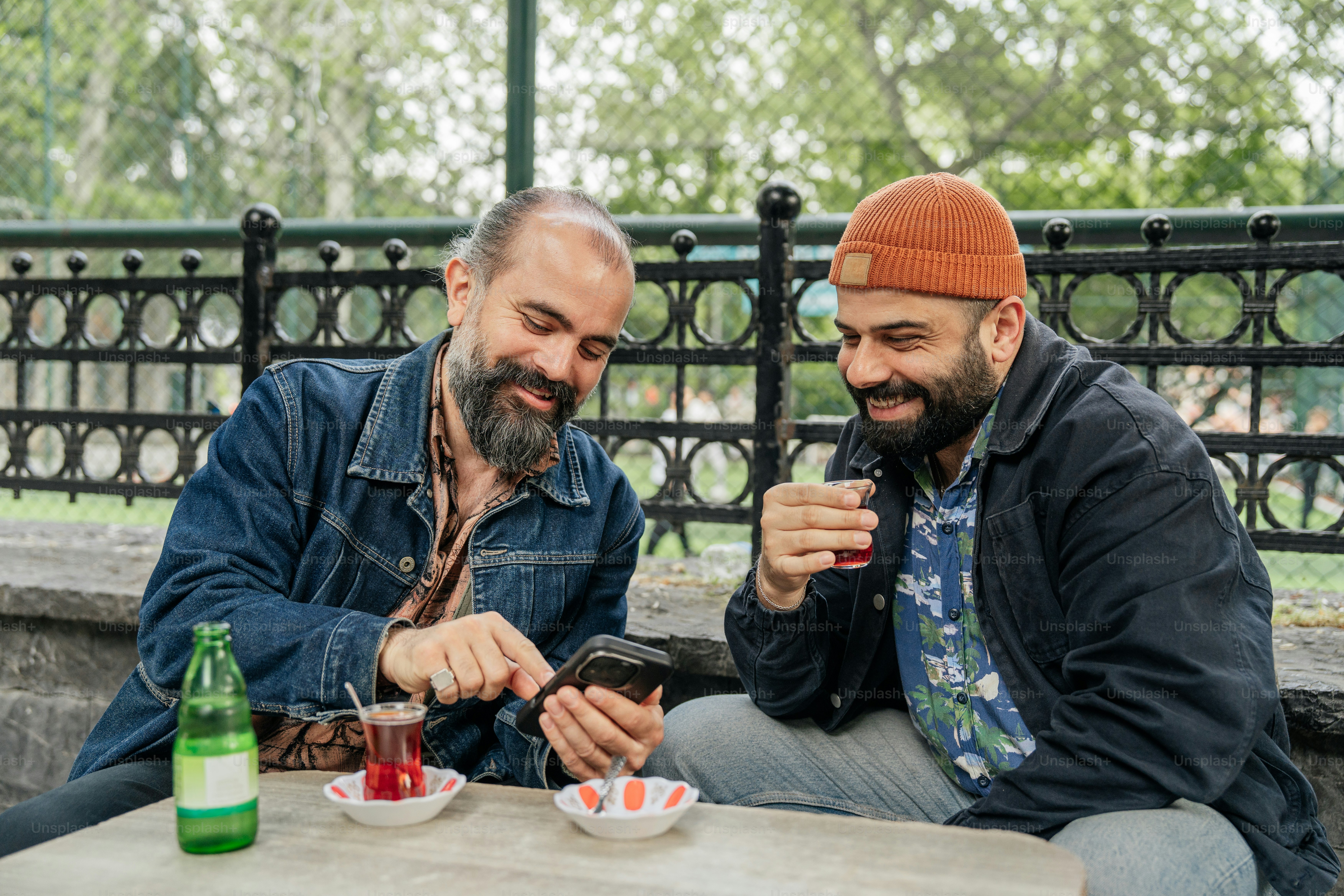 Two men are looking at a phone together.
