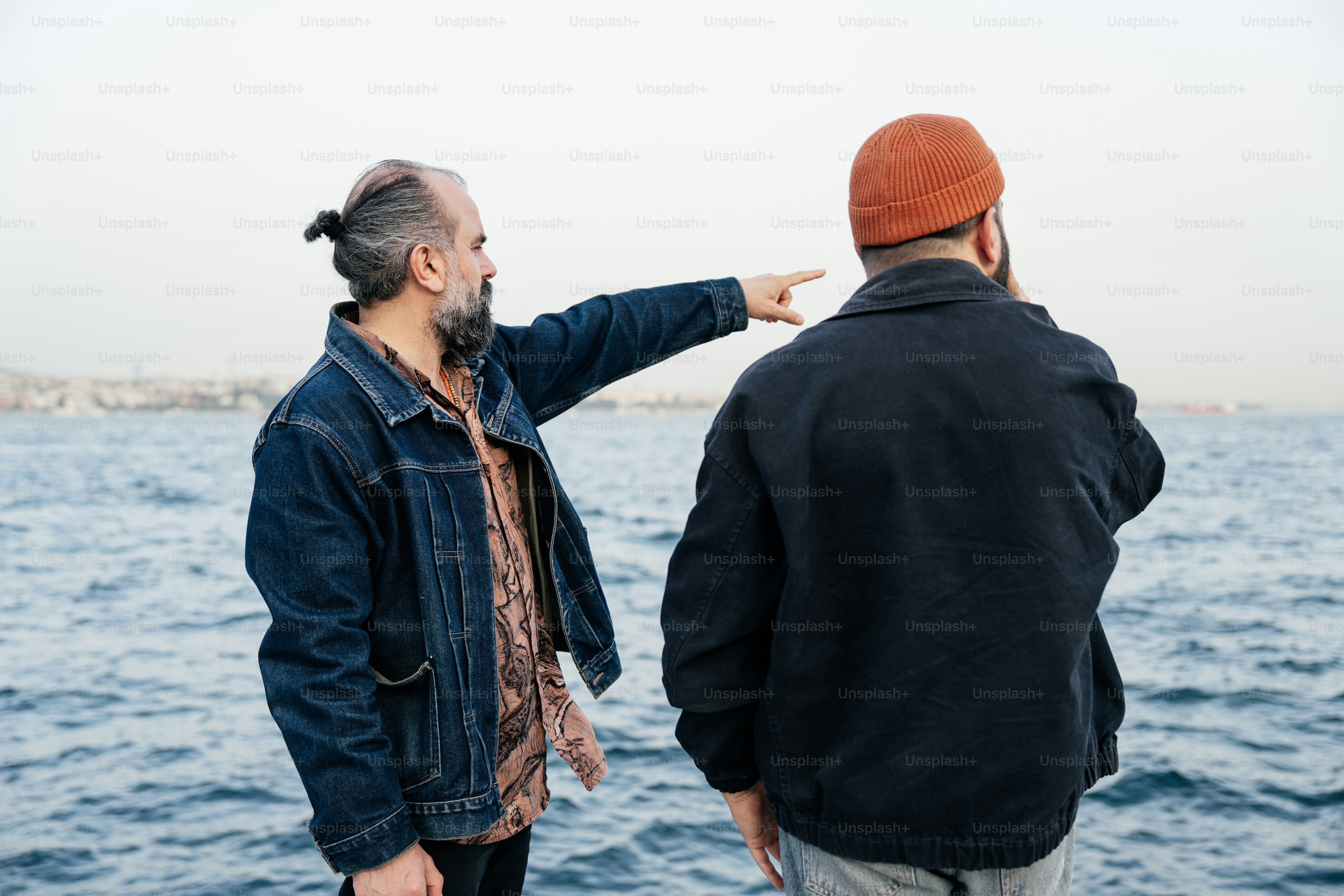 남자가 물 위에 있는 무언가를 가리킨다.