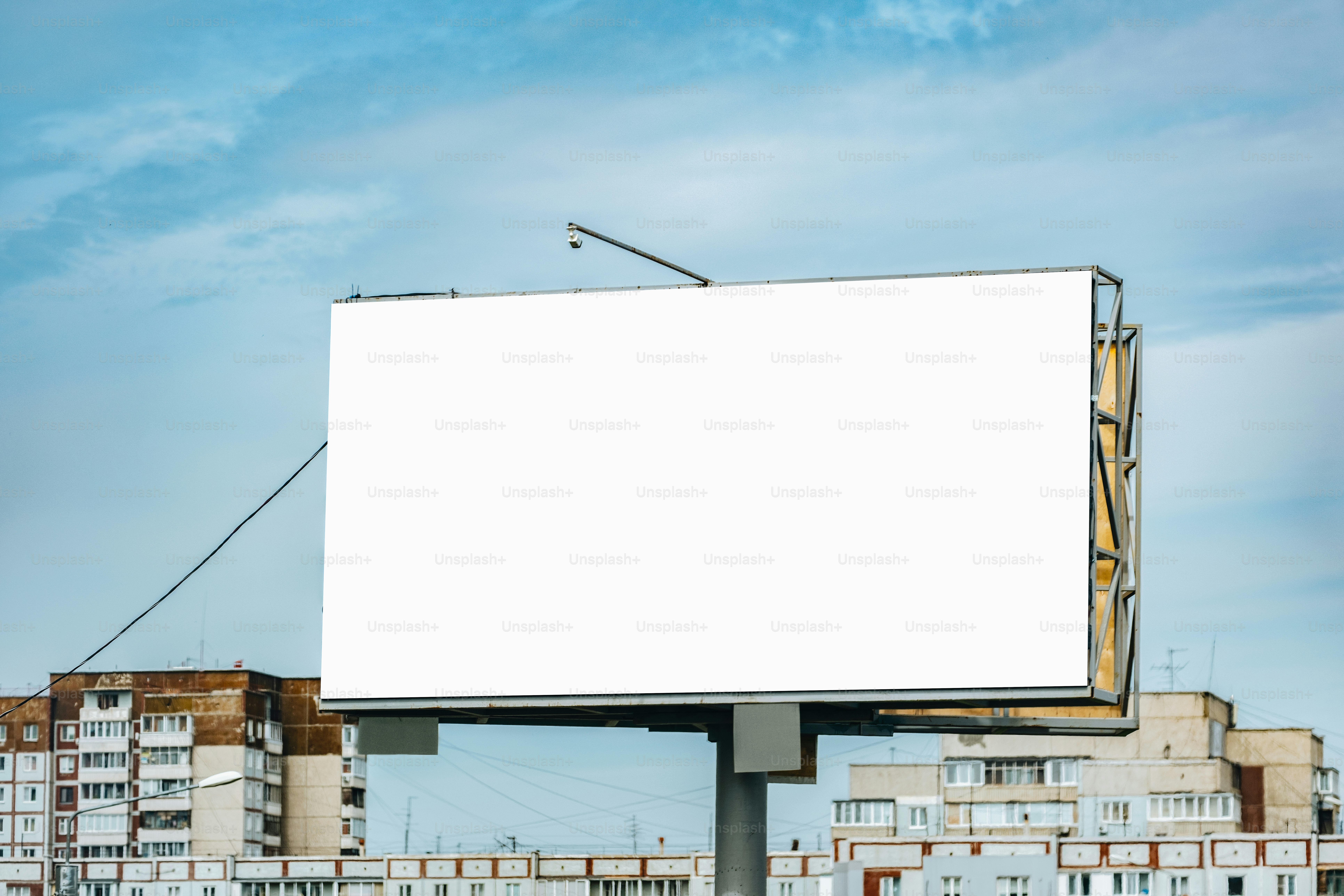 Una valla publicitaria en blanco se alza contra un cielo nublado.