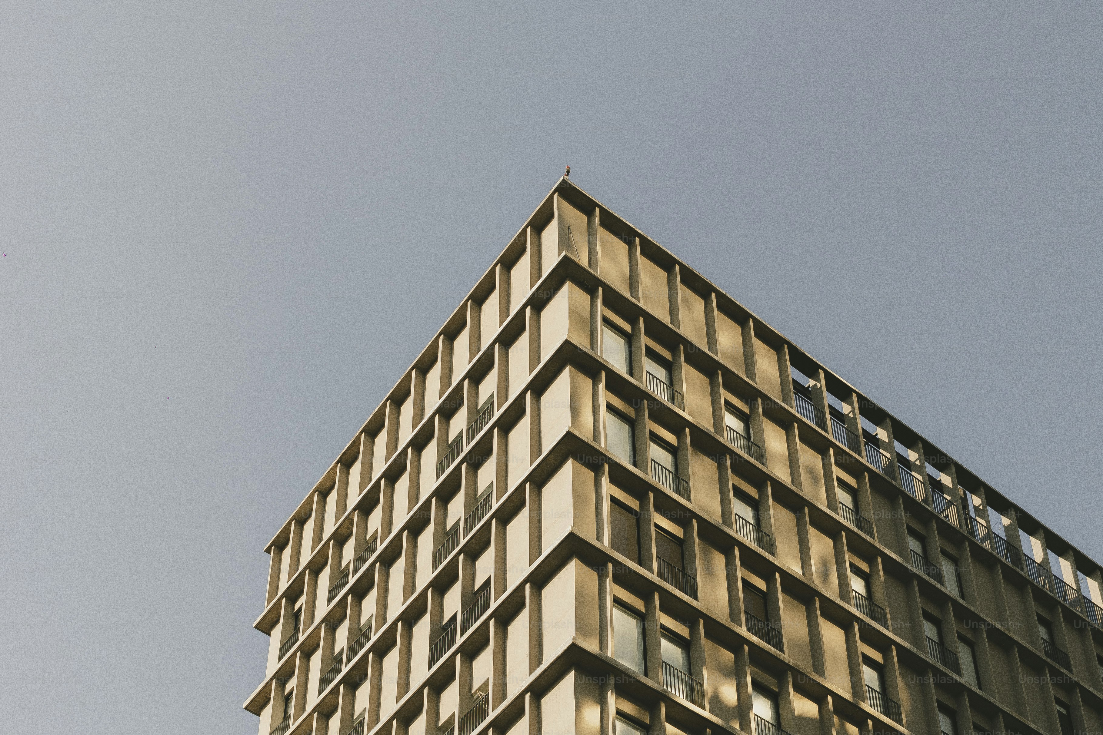 A modern building rises against a clear sky.
