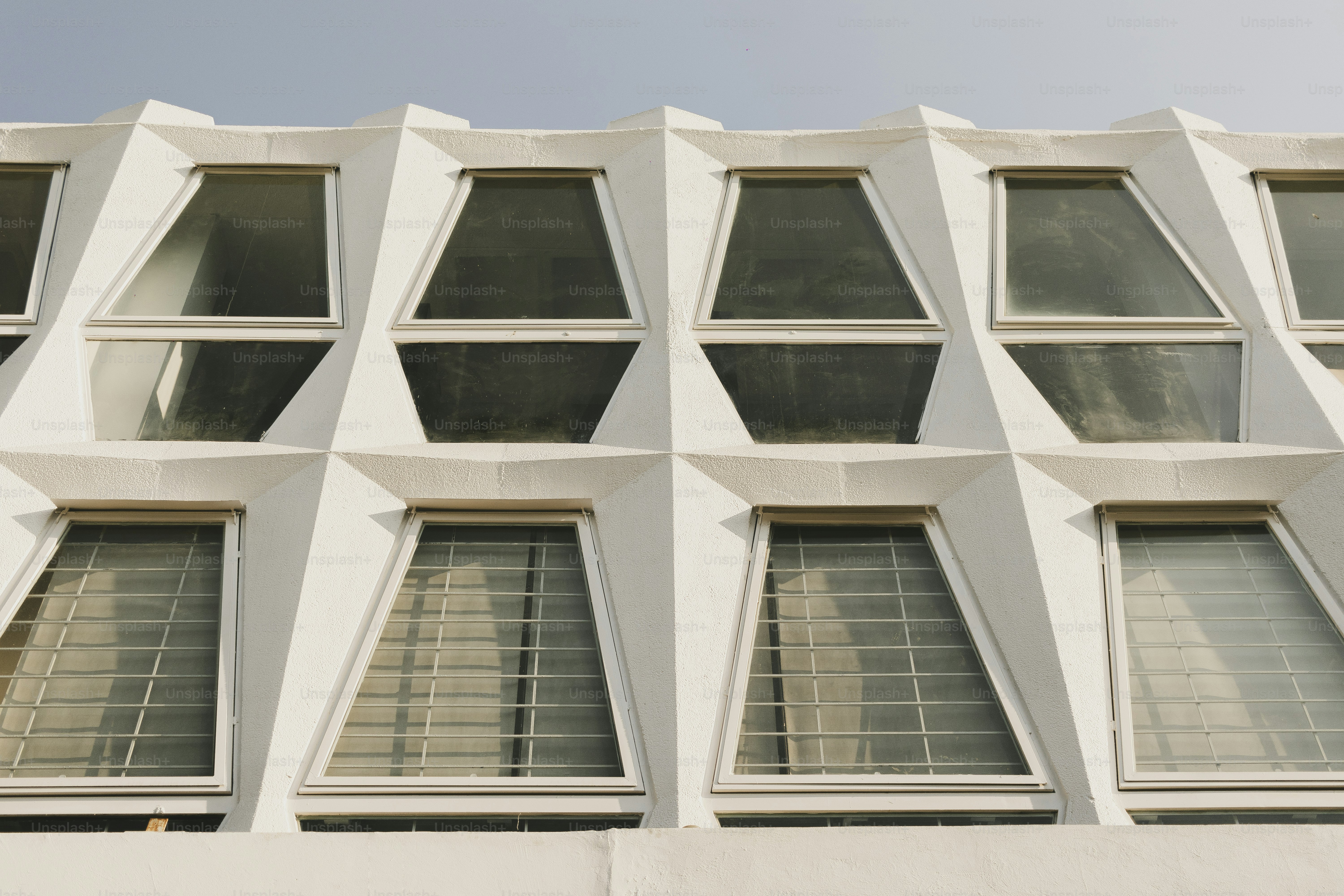Here is a possible caption: white building with unique, geometric windows.
