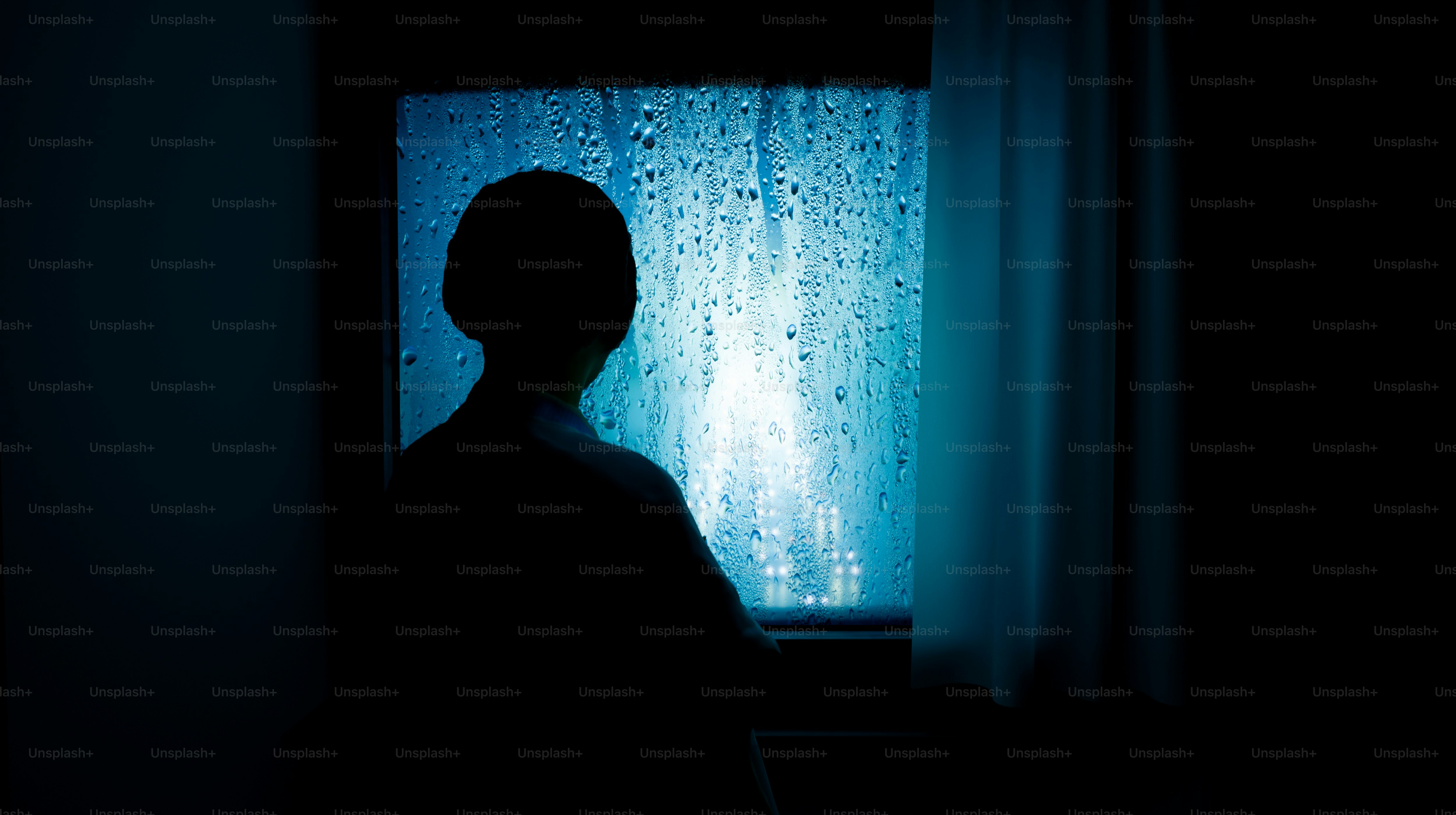 A young boy sitting alone by a window during rain, soft light, calm mood, reflective atmosphere