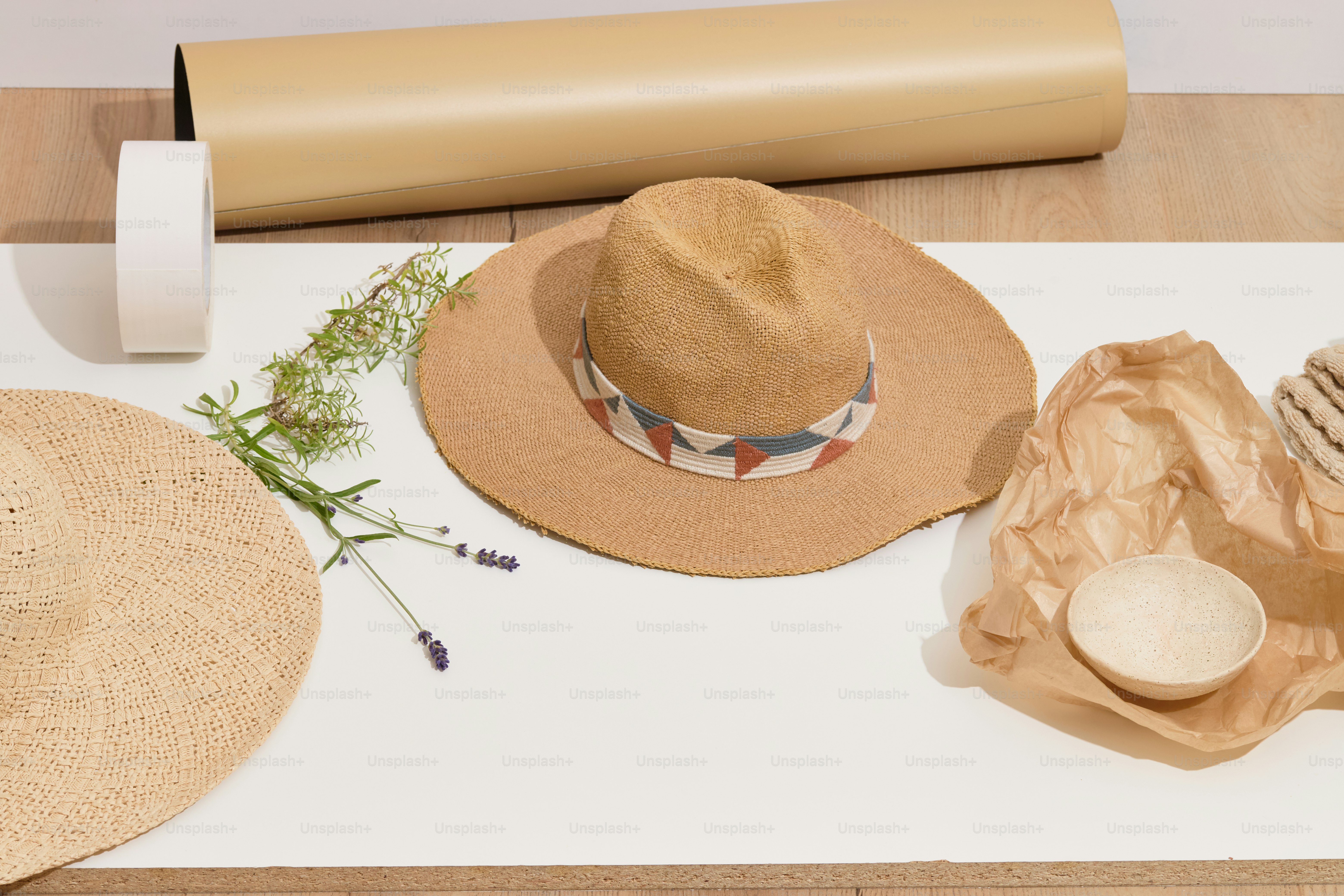 Hats, paper, and a bowl on a white surface.
