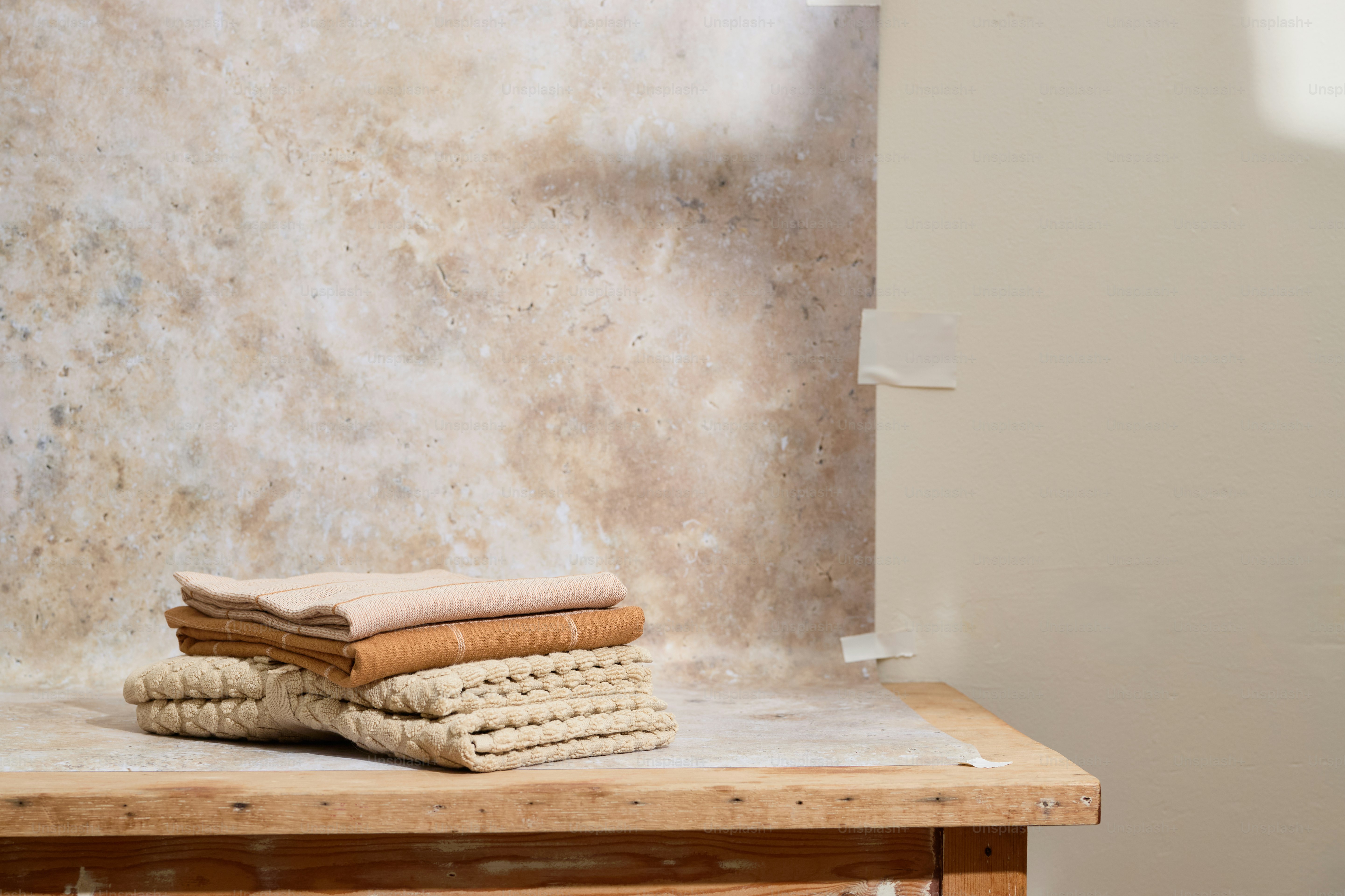 Les serviettes sont soigneusement empilées sur une surface en bois.