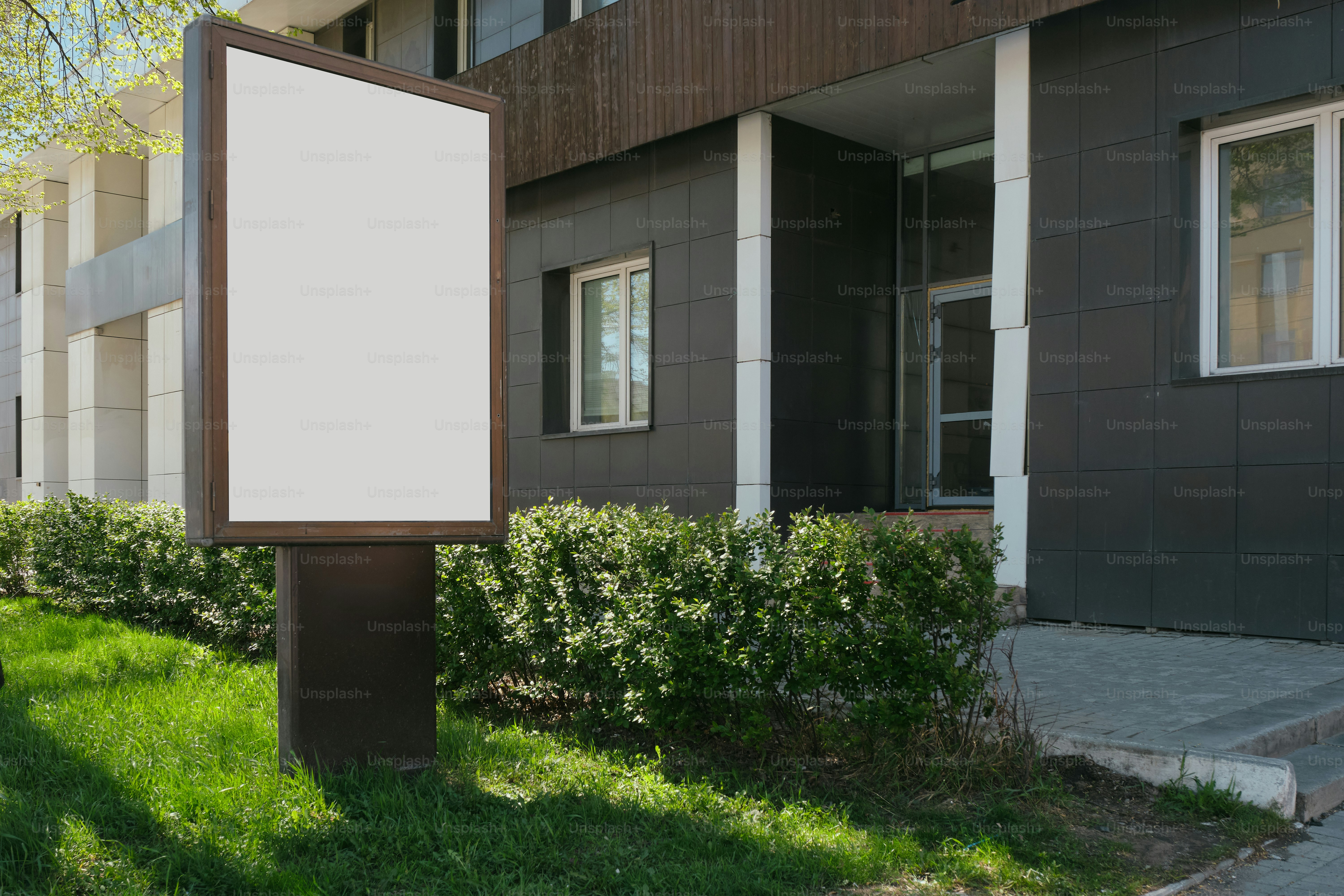 A blank billboard stands in front of a building.