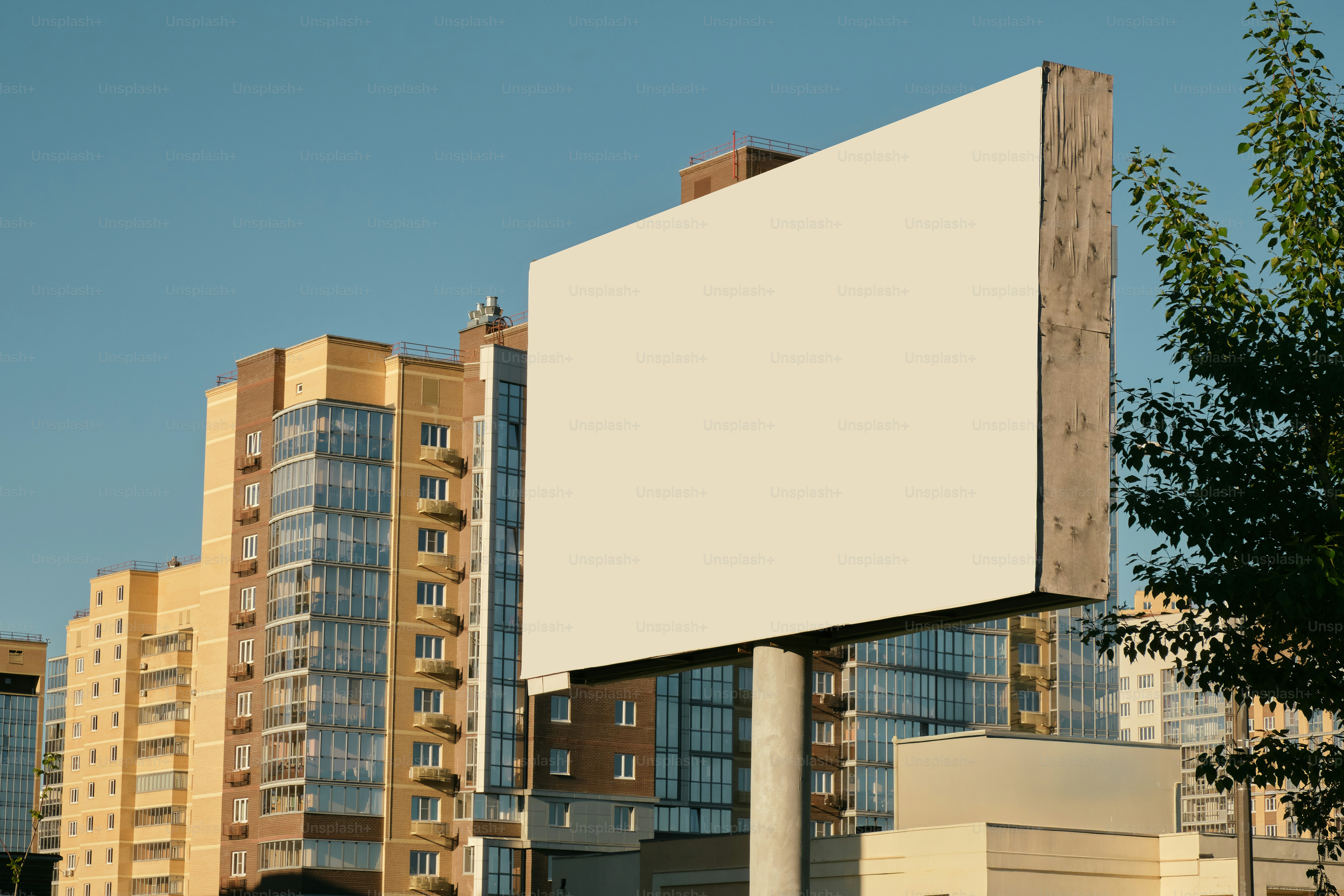 Una valla publicitaria en blanco se encuentra frente a los edificios.