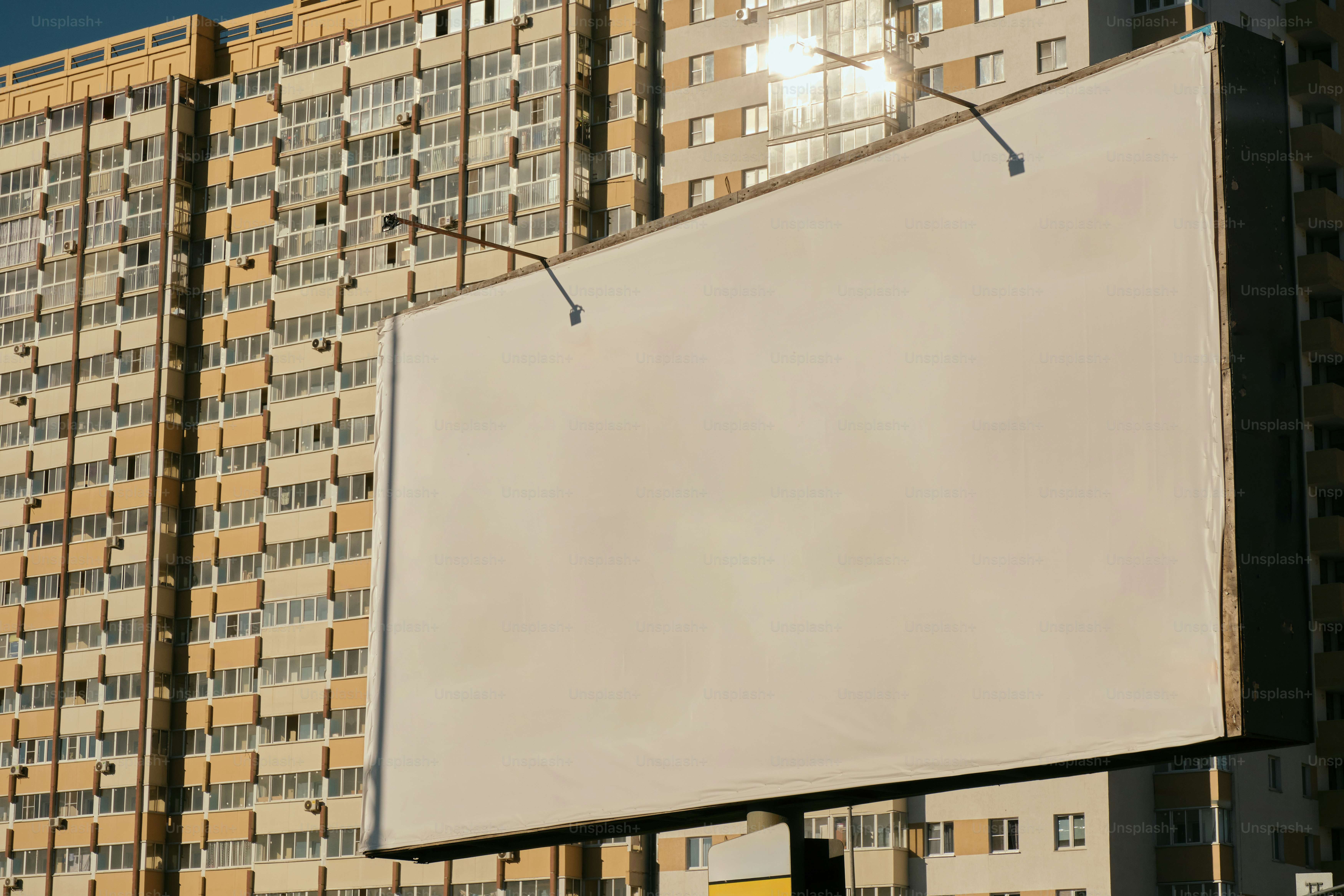 Eine leere Werbetafel steht vor einem Gebäude. Foto – Bild zum Thema Stadt  auf Unsplash, image size:3000x2000