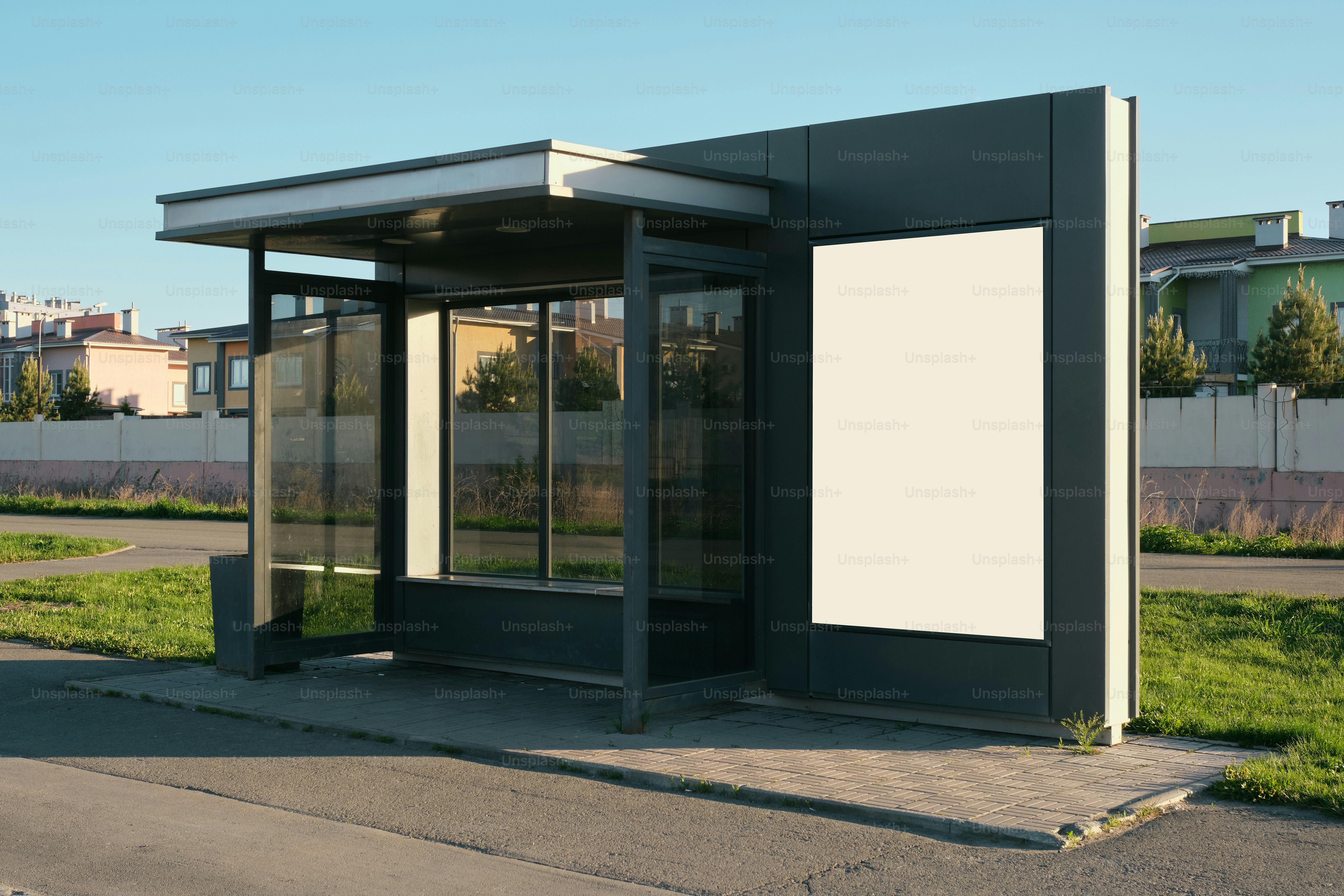 An empty bus stop with a billboard.