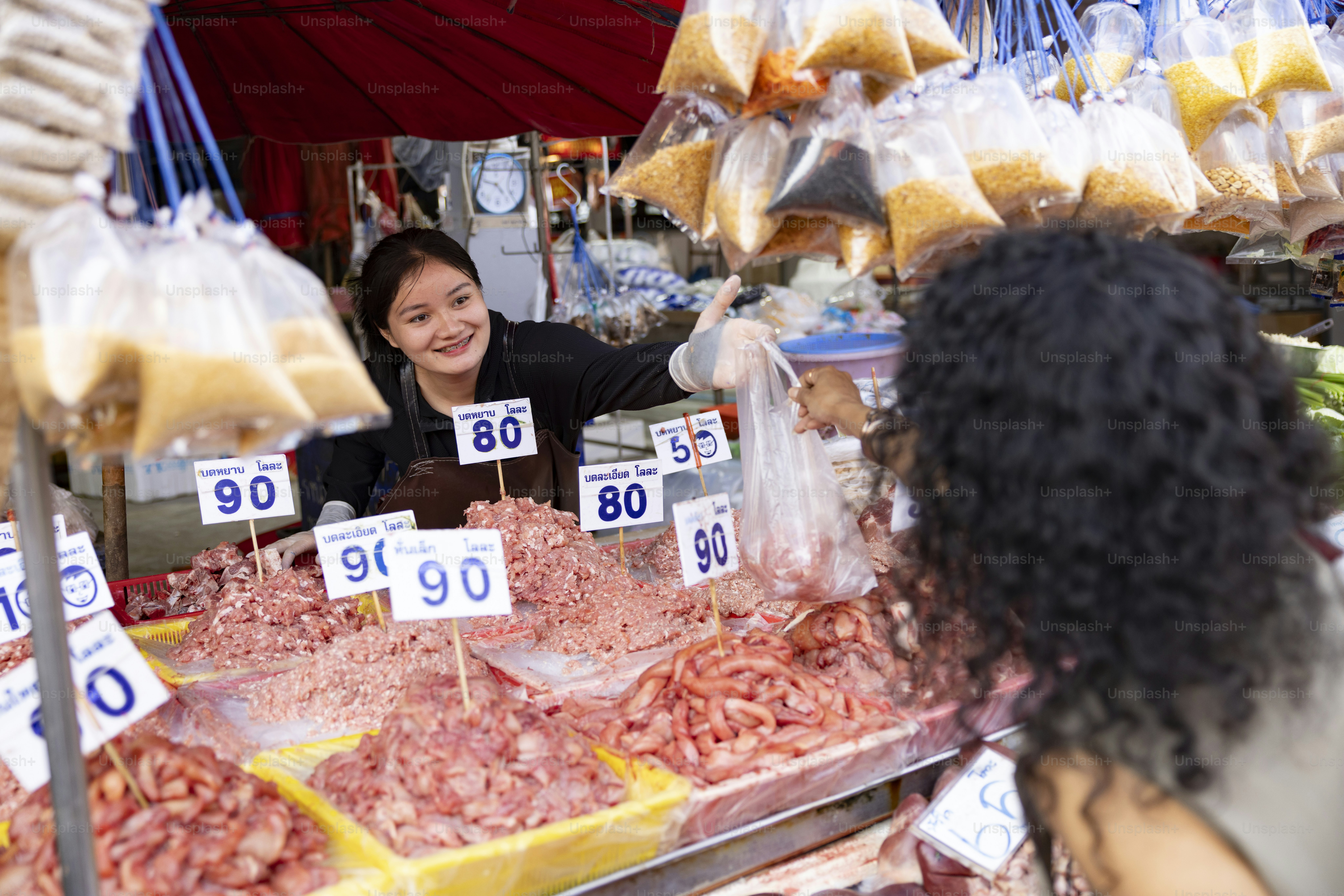Mulher vendendo comida em uma barraca de mercado movimentada.